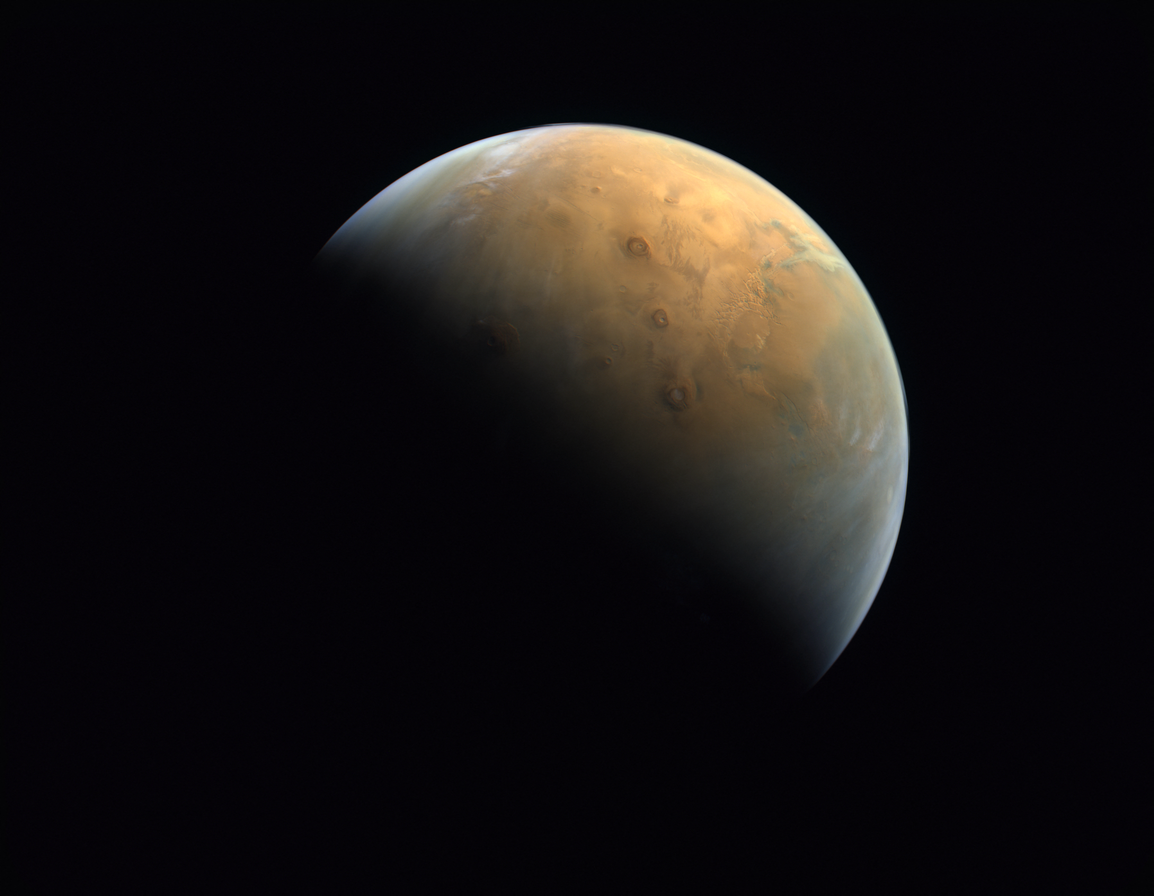 (FILES) A handout picture provided on February 14, 2021 by the United Arab Emirates Space Agency (UAESA) taken by the Emirates eXploration Imager (EXI) after Mars Orbit Insertion (MOI) on board the First Emirates Mars Mission (EMM) from an altitude of 24,700 km above the Martian surface shows the Olympus Mons, the highest volcano on Mars, and the Tharsis Montes, three volcanoes named (top to bottom) Ascraeus Mons, Pavonis Mons and Arsia Mons.