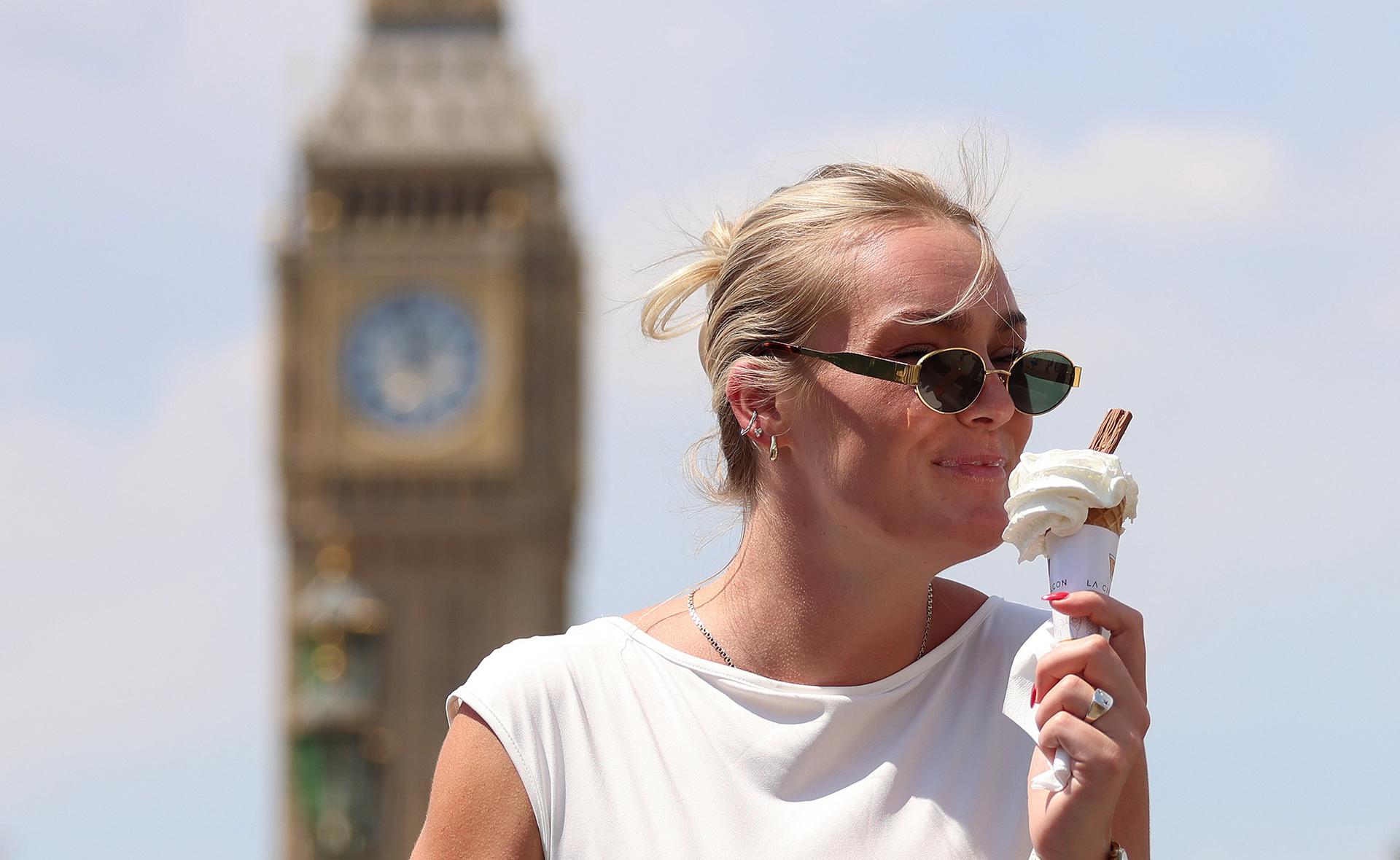 LONDON (United Kingdom), 01/07/2025.- A woman eats an ice-cream on Westminster Bridge in London, Britain, 01 July 2025. The UK has recorded its hottest day of the year so far with temperatures reaching 33.6 degrees Celsius. Much of Europe is in the grip of a heatwave with temperatures in Spain and Portugal exceeding 45 degrees Celsius. (España, Reino Unido, Londres) EFE/EPA/ANDY RAIN
