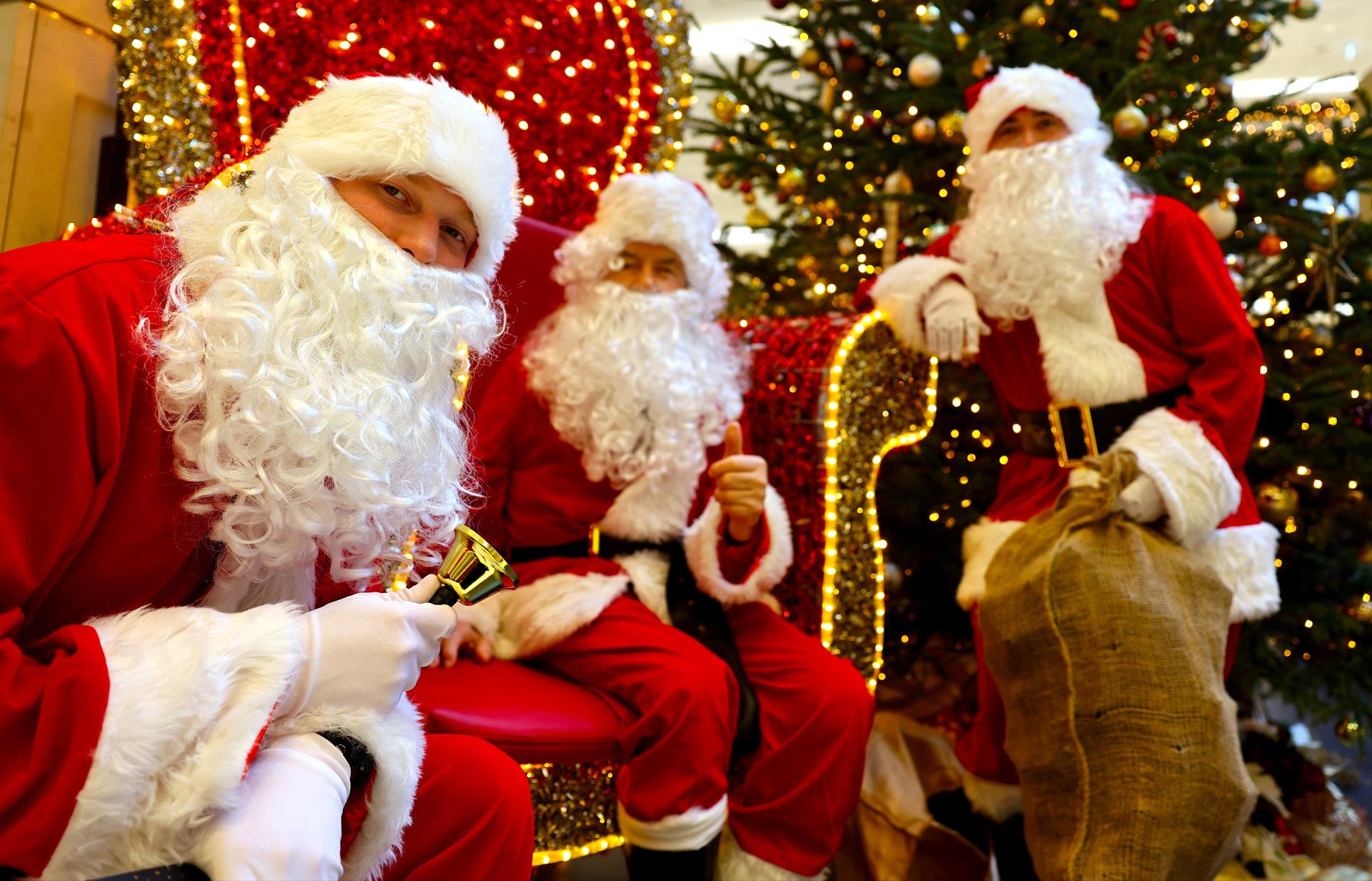 Berlin (Germany), 20/12/2025.- Men dressed as Santa Claus pose for pictures in a shopping mall in Berlin, Germany, 20 December 2025. (Alemania) EFE/EPA/HANNIBAL HANSCHKE