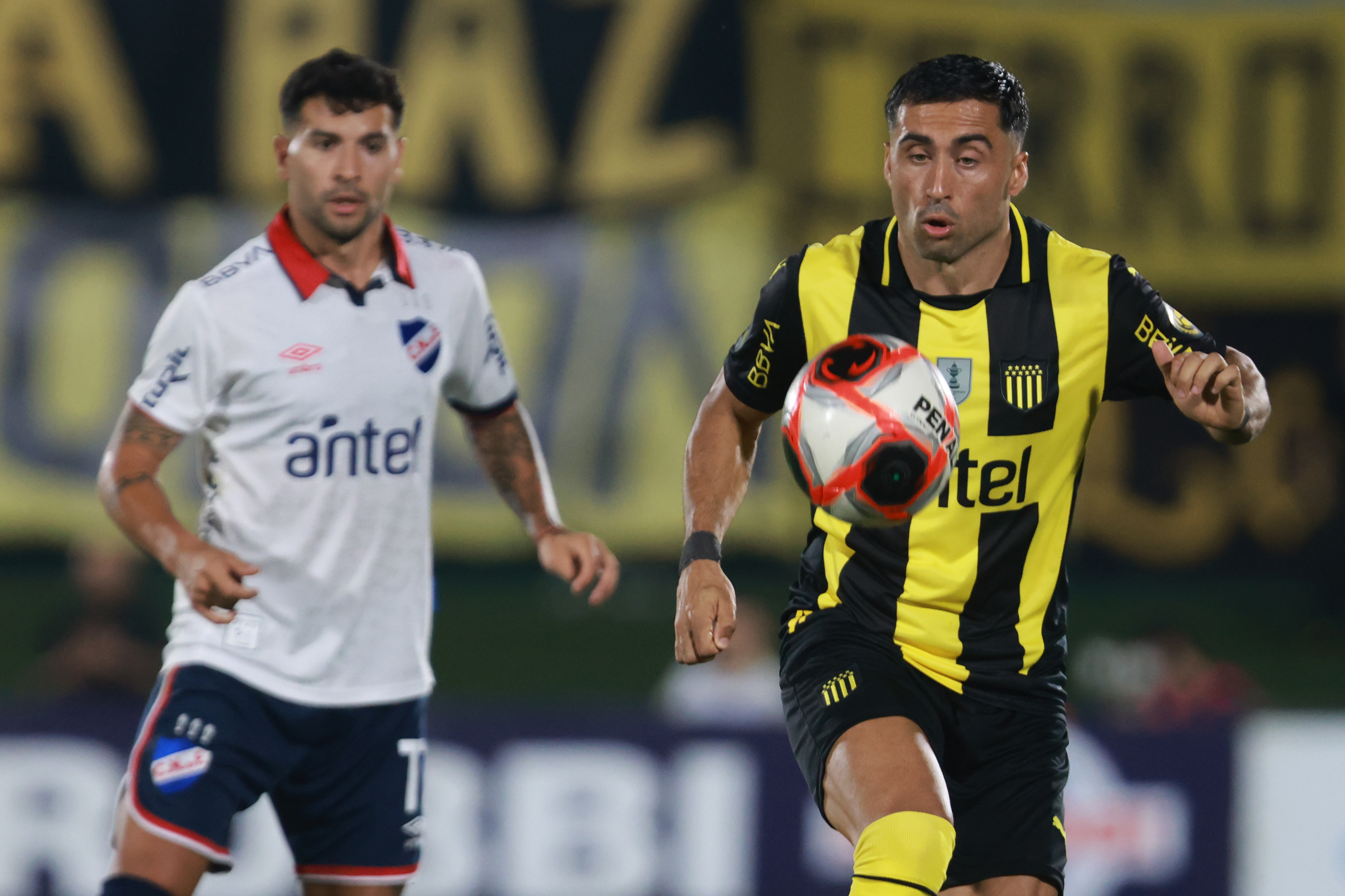 AMDEP1348. MONTEVIDEO (URUGUAY), 26/01/2025.- Jaime Baéz (d) de Peñarol controla un balón este domingo, en un partido por la final de la Supercopa Uruguaya entre Nacional y Peñarol en el estadio Centenario en Motenvideo (Uruguay). EFE/ Gaston Britos
