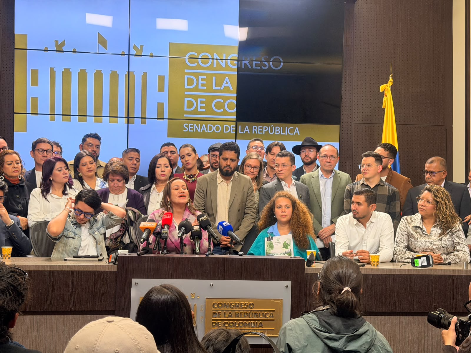 Fotografía de un acto oficial en el Congreso de la República de Colombia. En el recinto del Senado, un grupo numeroso de personas acompaña a un orador en el podio, frente a micrófonos y bajo una pantalla institucional con los logos del Congreso y el Senado. A la derecha se observa la bandera de Colombia. La escena corresponde a la presentación de la nueva iniciativa de estatuto del trabajo ante el Congreso.