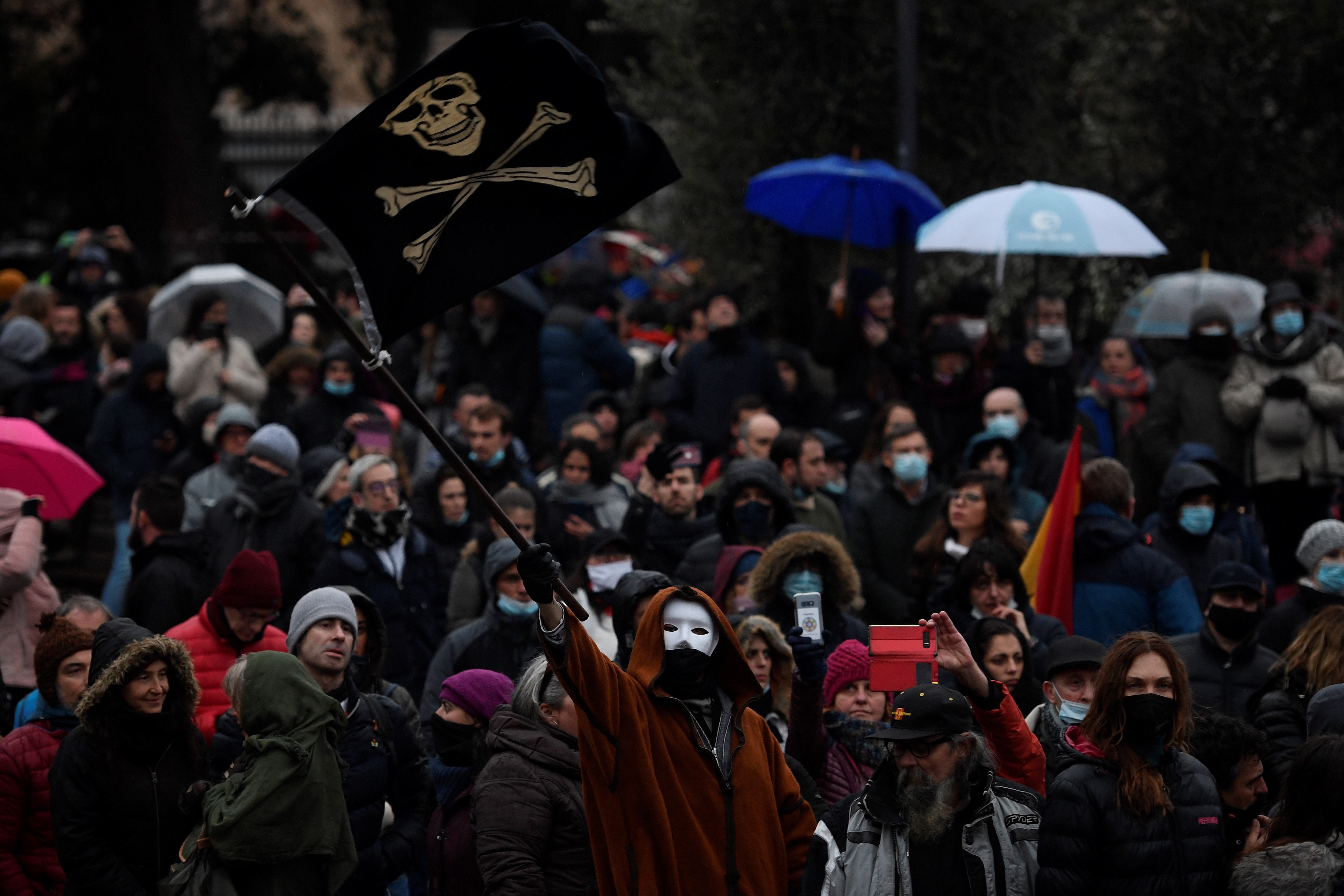 Un hombre ondea una bandera pirata mientras los manifestantes se reúnen para protestar contra las restricciones del coronavirus en Madrid el 23 de enero de 2021.