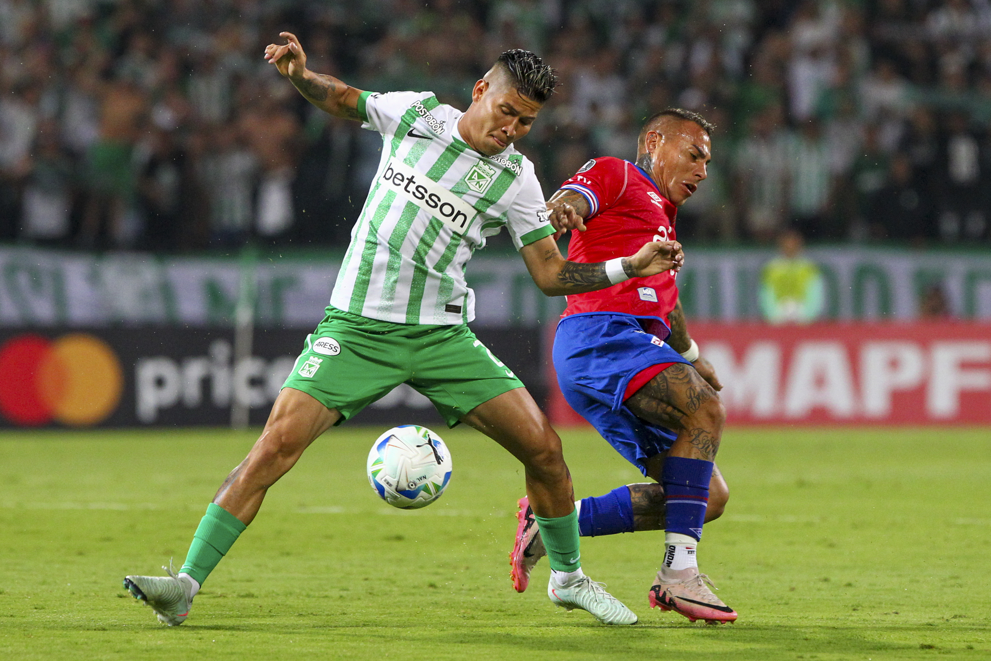 AMDEP4726. MEDELLÍN (COLOMBIA), 02/04/2025.- Jorman Campuzano (i) de Atlético Nacional disputa un balón con Eduardo Vargas de Nacional este miércoles, en un partido de la fase de grupos de la Copa Libertadores entre Atlético Nacional y Nacional de Uruguay en el estadioAtanasio Girardot en Medellín (Colombia). EFE/ STR