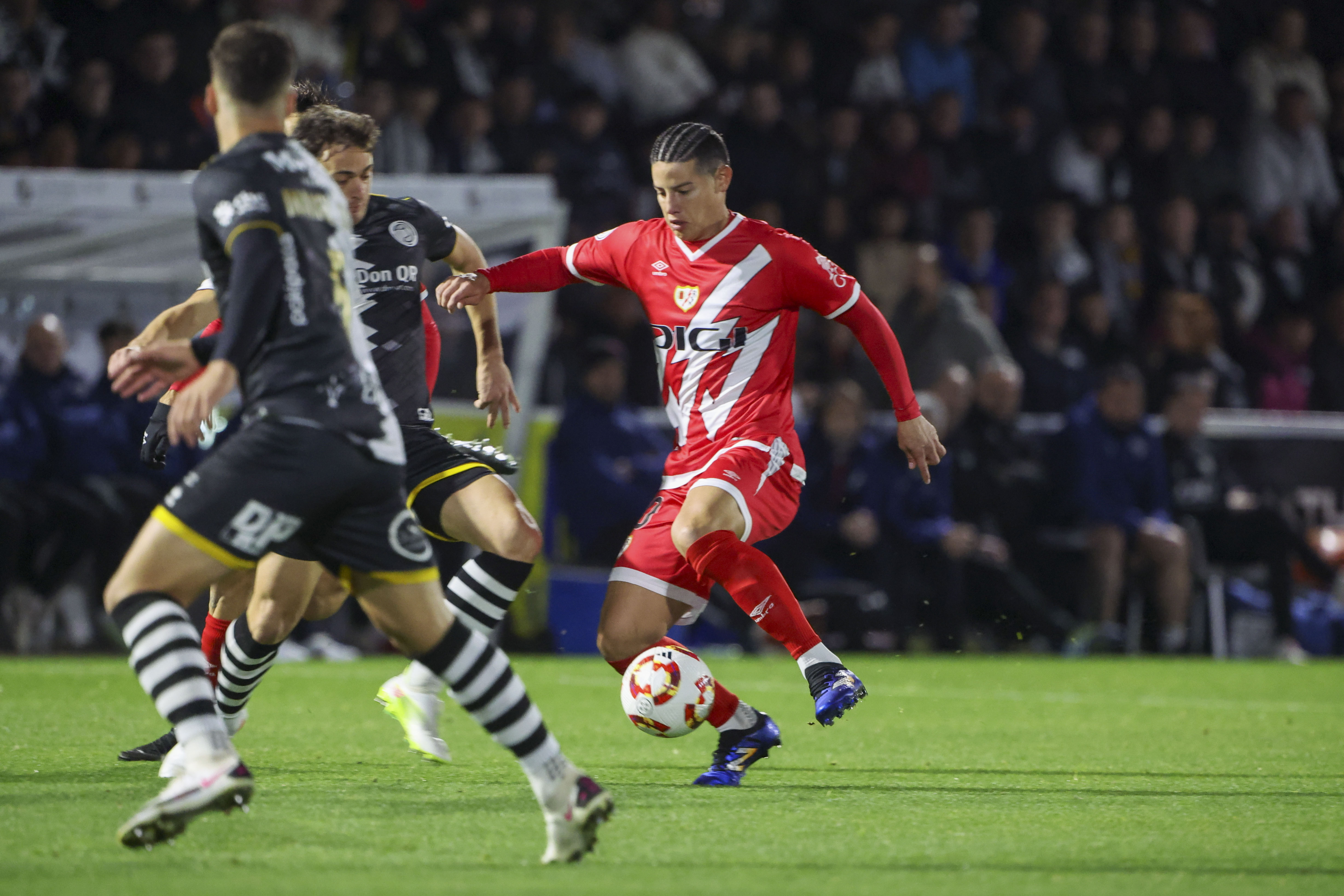 SALAMANCA, 04/12/2024.- El centrocampista colombiano del Rayo Vallecano, James Rodríguez (d), conduce el balón ante los jugadores del Unionistas CF correspondiente a la segunda ronda de la Copa del Rey que disputan hoy miércoles Unionistas CF y Rayo Vallecano en el estadio municipal Reina Sofia de Salamanca. EFE/JMGARCIA.