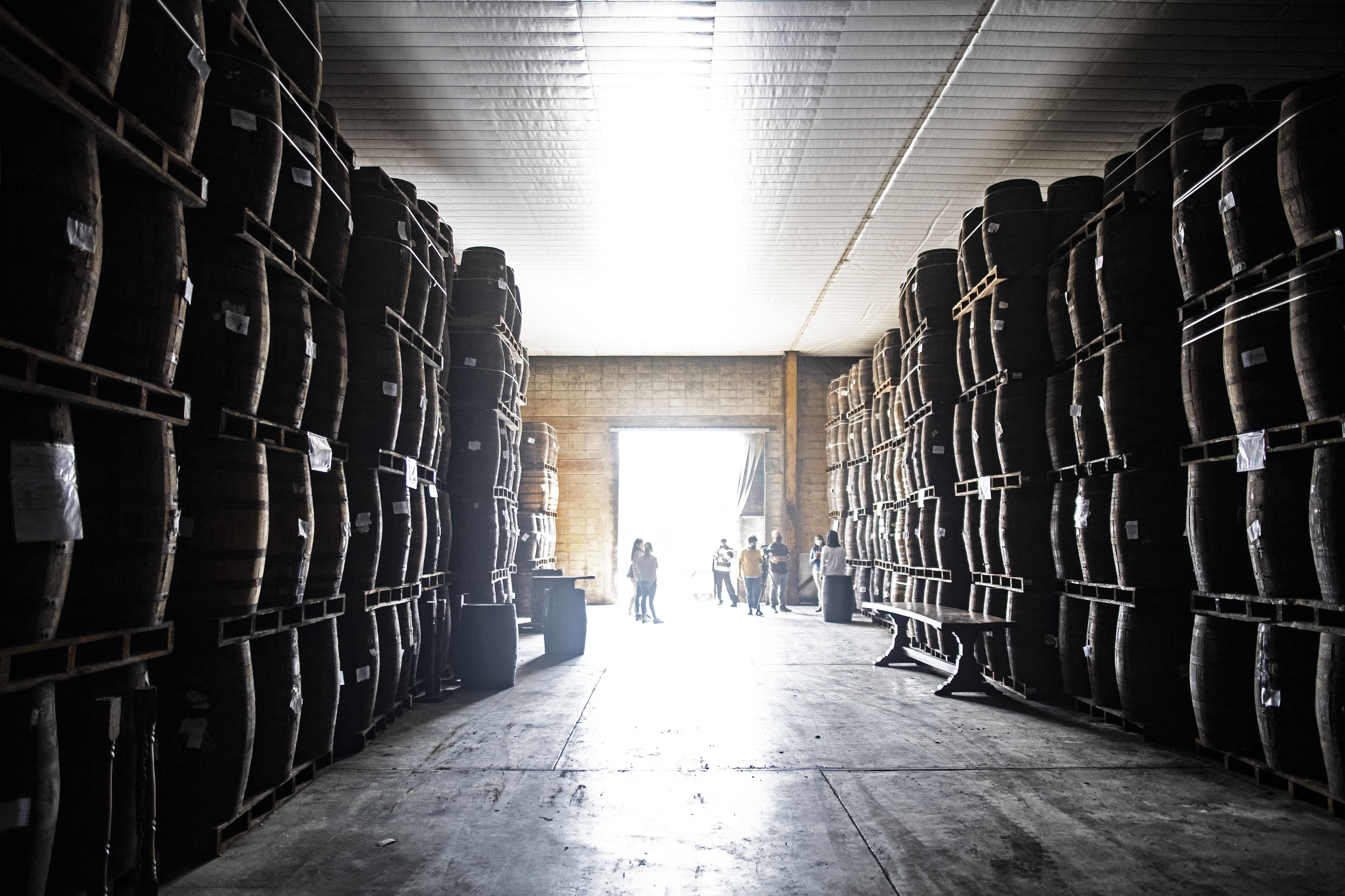 La gente visita una bodega con barriles de ron que permanecen en proceso de añejamiento en un almacén de la Hacienda Santa Teresa en El Consejo, Venezuela.
