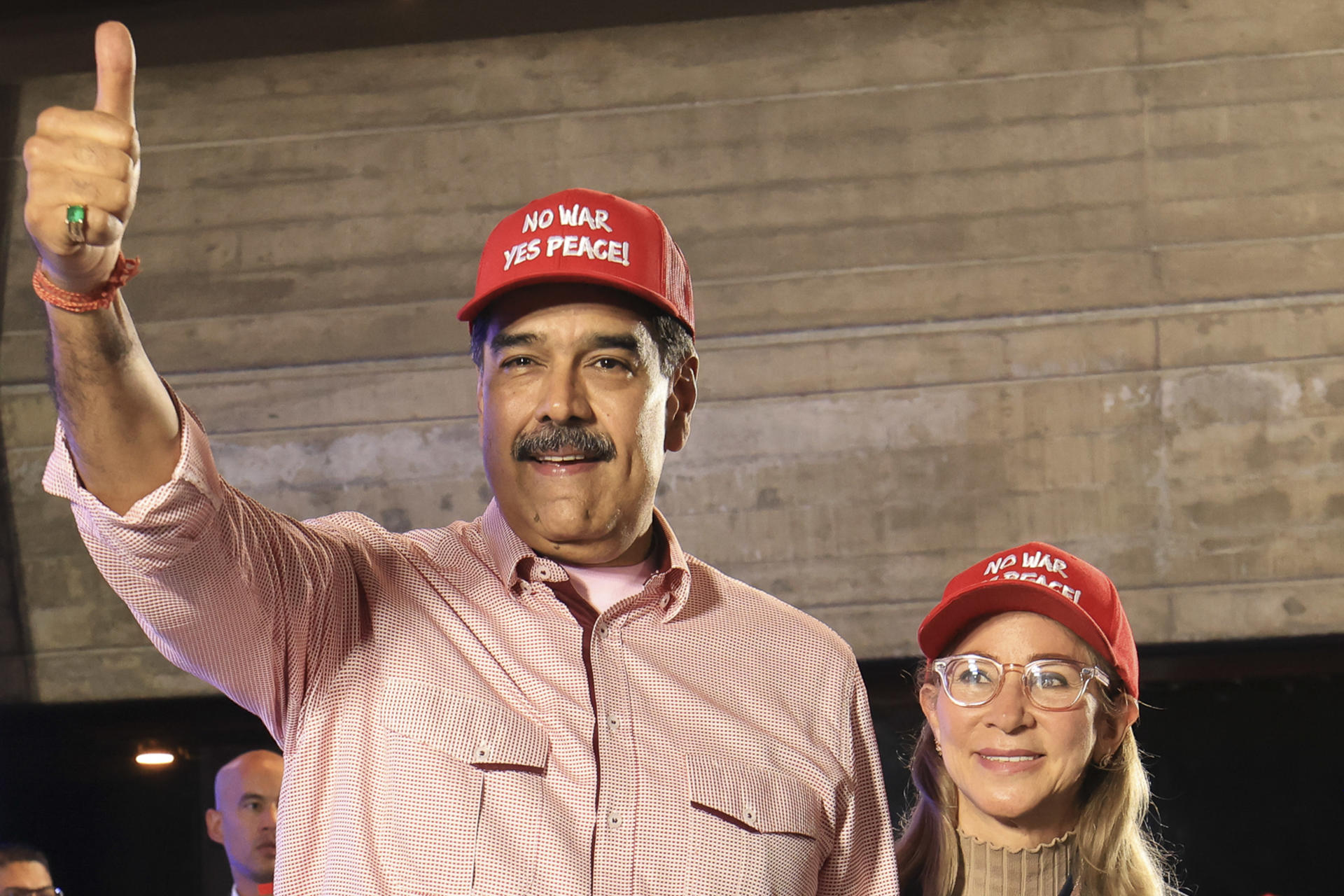 AME8868. CARACAS (VENEZUELA), 16/12/2025.- Fotografía cedida por Prensa Miraflores del presidente de Venezuela, Nicolás Maduro, saludando junto a la primera dama de Venezuela, Cilia Flores, en un acto de gobierno este martes, en Caracas (Venezuela). Maduro dijo que su país ha enfrentado y está "derrotando" lo que llamó "agresión multidimensional" de Estados Unidos desde hace 25 semanas, en referencia al inicio del despliegue militar del país norteamericano en el mar Caribe, cerca de las aguas venezolanas. EFE/ Prensa Miraflores /SOLO USO EDITORIAL/NO VENTAS/ SOLO DISPONIBLE PARA ILUSTRAR LA NOTICIA QUE ACOMPAÑA (CRÉDITO OBLIGATORIO)
