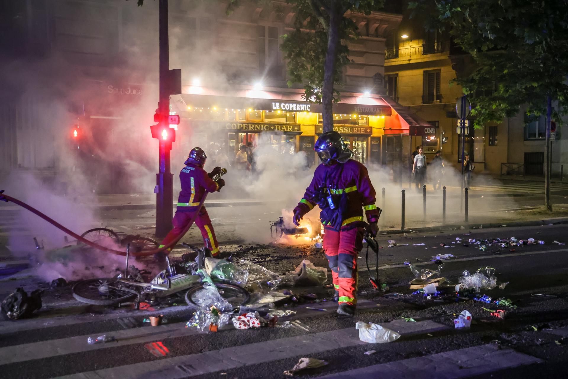 Paris (France), 31/05/2025.- French firefighters extinguish a street fire as clashes erupt between French police and fans of PSG celebrating their team win of the UEFA Champions League final between Paris Saint-Germain and Internazionale Milano, Paris, France, 31 May 2025. (Liga de Campeones, Francia) EFE/EPA/CHRISTOPHE PETIT TESSON