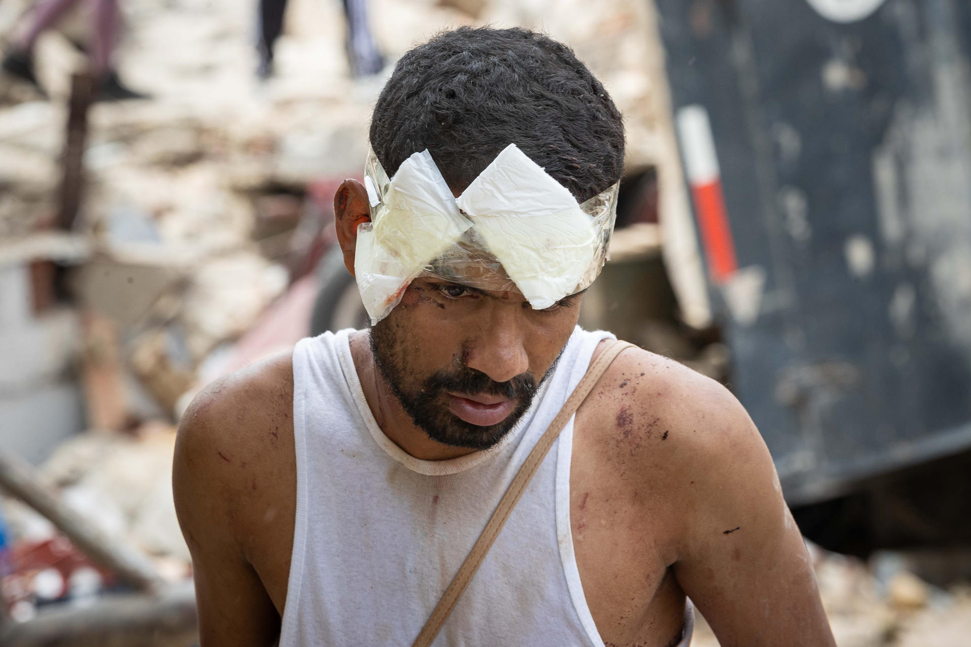 AME4361. LA GUAIRA (VENEZUELA), 25/06/2026.- Una persona herida camina entre los escombros de edificios derrumbados este jueves, en La Guaira (Venezuela). El número de fallecidos en Venezuela a causa de los dos terremotos del miércoles se elevó a 188 y el de heridos a 1.520, mientras que al menos 346 construcciones, entre edificios, hospitales y centros comerciales, resultaron afectadas, informó el presidente de la Asamblea Nacional (AN, Parlamento), el chavista Jorge Rodríguez. EFE/ Ronald Peña R.
