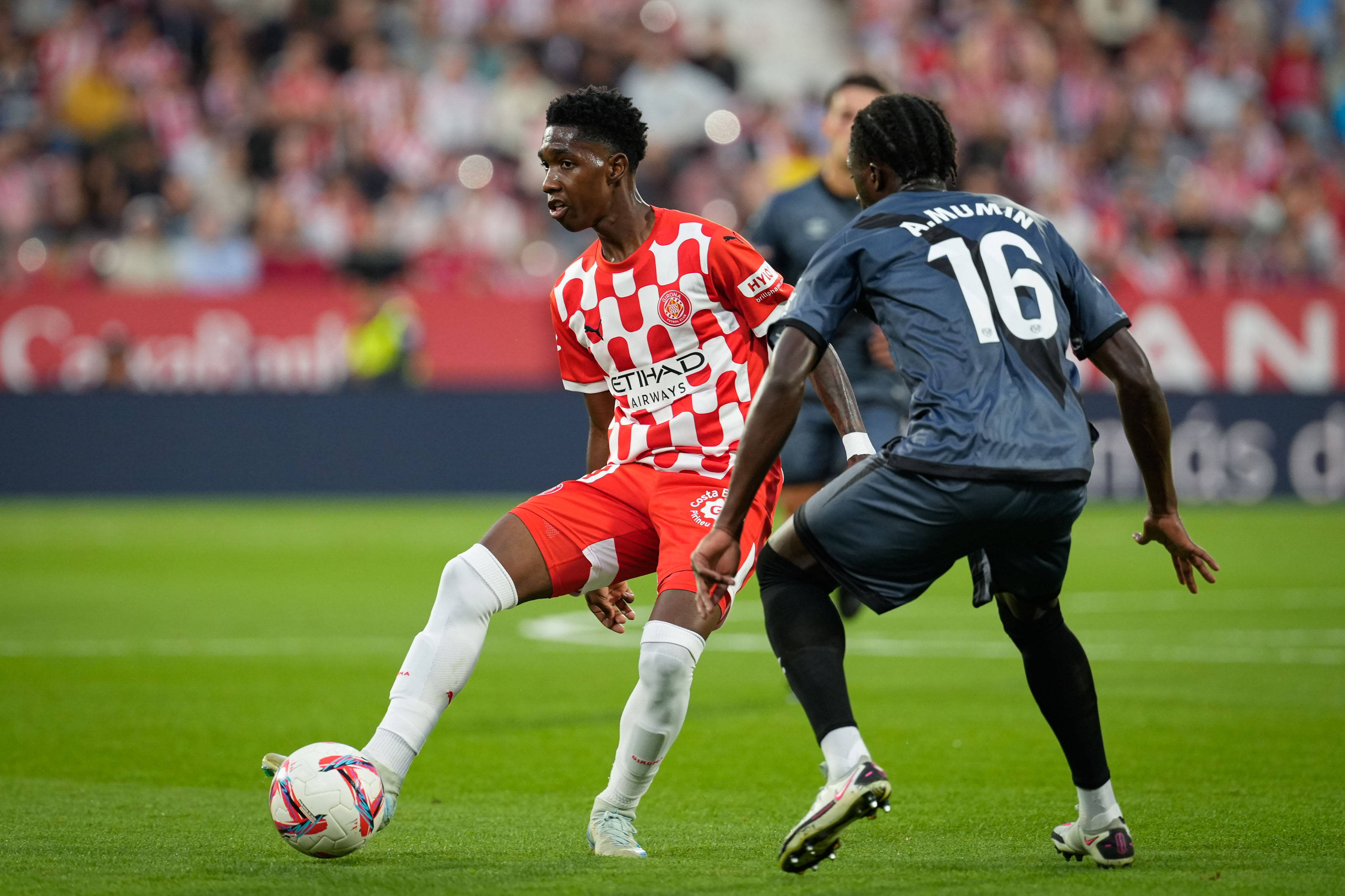GIRONA, 25/09/2024.- El delantero colombiano del Girona Yáser Asprilla (i) disputa un balón con el defensa ghanés del Rayo Abdul Mumin (d) durante el partido de la jornada 7 de LaLiga entre Girona FC y Rayo Vallecano, este miércoles en el estadio Municipal de Montilivi, en Girona.EFE/ David Borrat