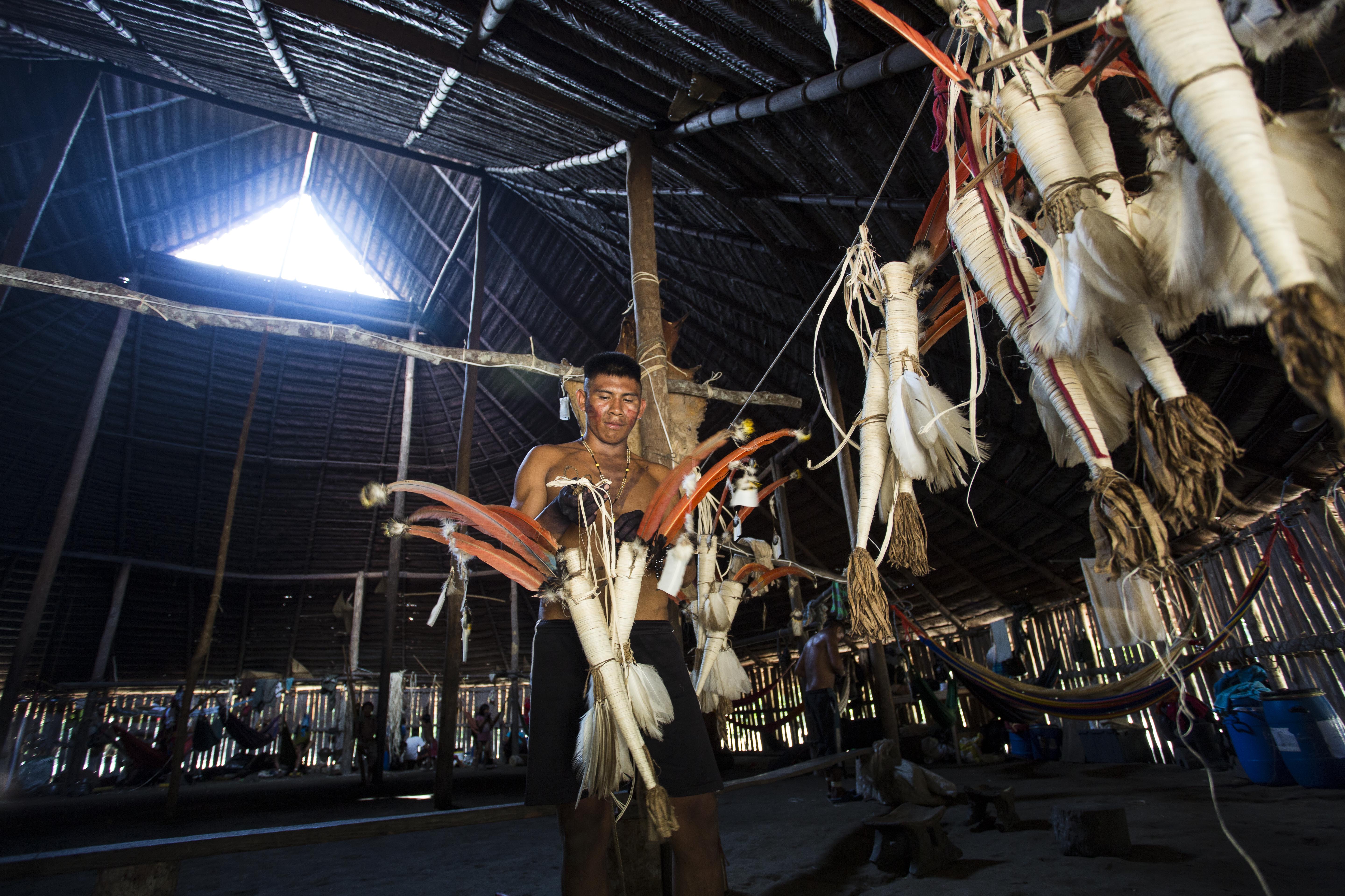 Joven indígena del resguardo Yaigojé Apaporis alistando traje tradicional para ritual amazónico.