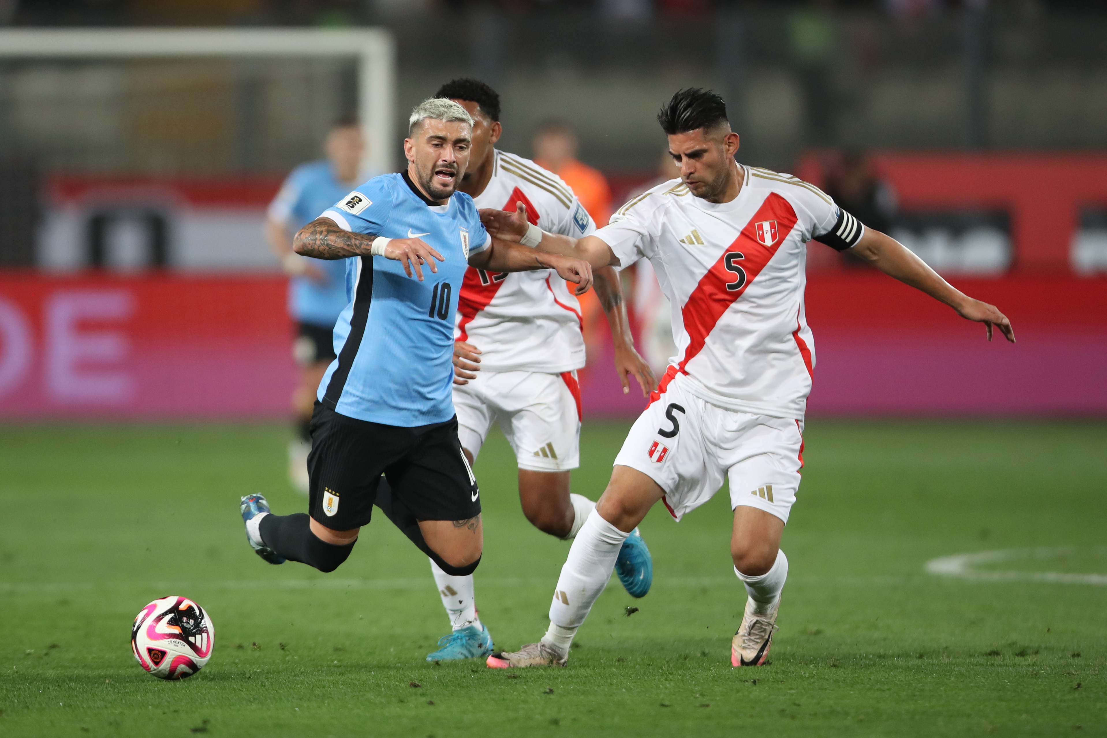 . LIMA (PERÚ), 11/10/2024.- Carlos Augusto Zambrano (d) de Perú disputa un balón con Giorgian De Arrascaeta de Uruguay este viernes, en un partido de las eliminatorias sudamericanas para el Mundial de 2026 entre Perú y Uruguay en el estadio Nacional de Perú en Lima (Perú). EFE/ Paolo Aguilar