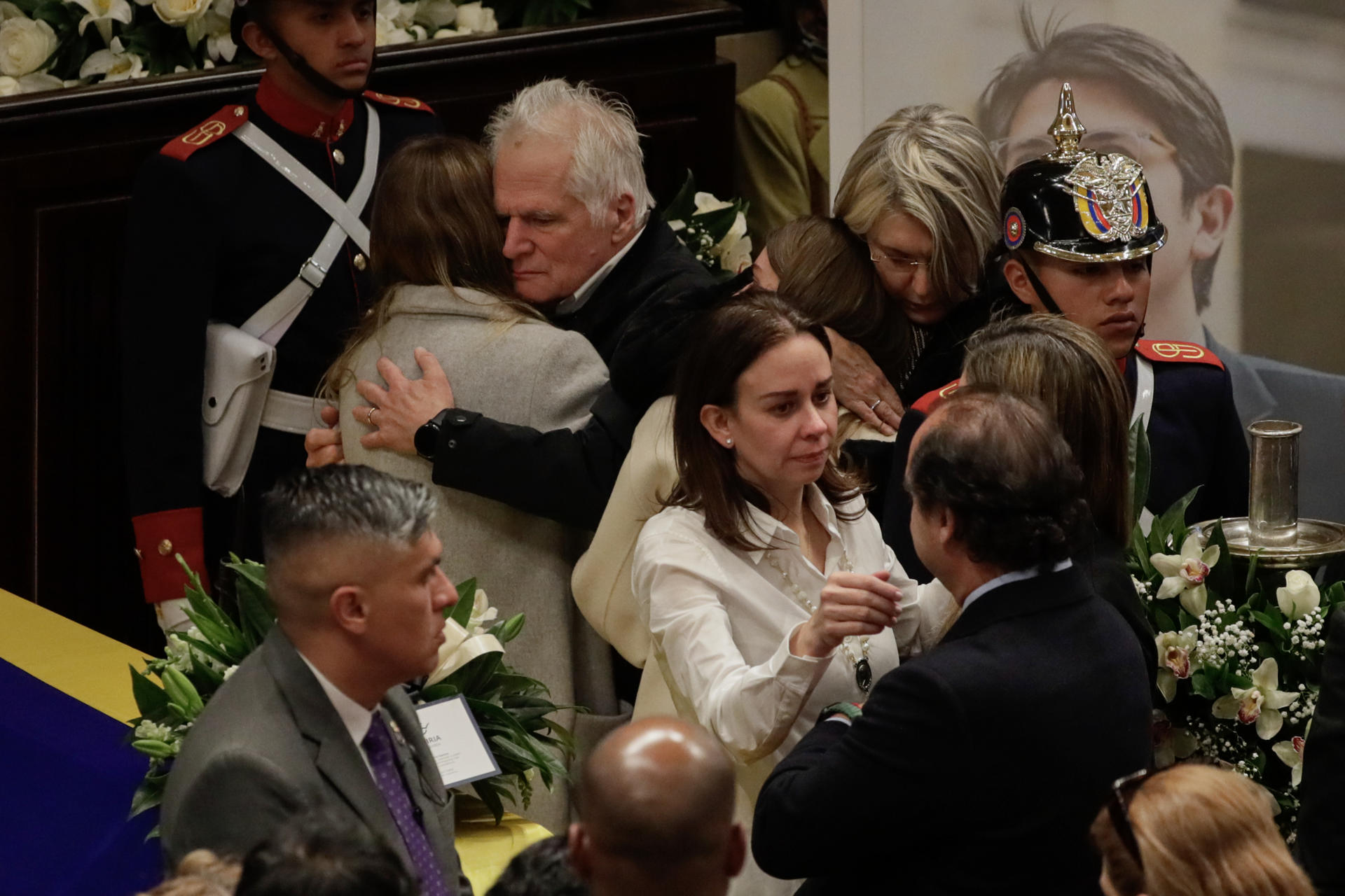 AME9339. BOGOTÁ (COLOMBIA), 11/08/2025.- La esposa del fallecido senador y precandidato a la presidencia de Colombia Miguel Uribe Turbay, Claudia Tarazona (c), sus hijas y el padre de Miguel, Miguel Uribe (c, atrás), se abrazan junto al féretro este lunes, en el Salón Elíptico del Capitolio Nacional en Bogotá (Colombia). Uribe Turbay falleció después de ser gravemente herido en un atentado hace 64 días. EFE/ Carlos Ortega