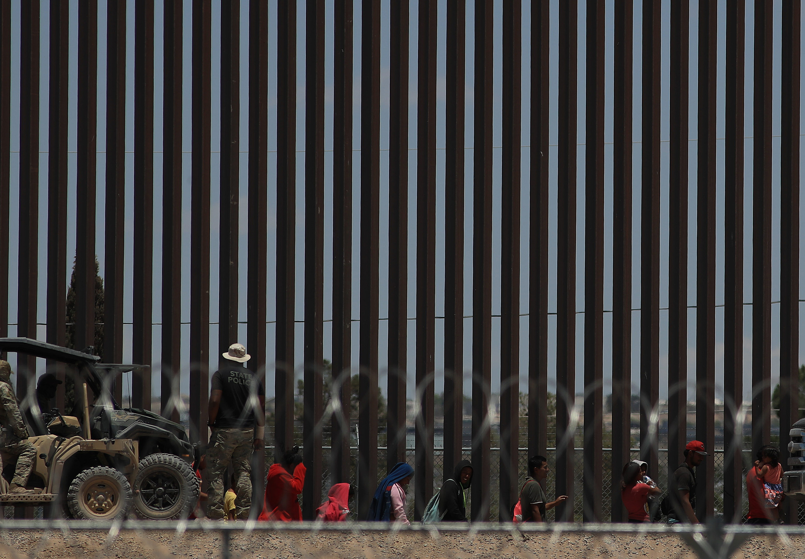 MEX9628. CIUDAD JUÁREZ (MÉXICO), 31/05/2024.- Policías de la Guardia Nacional de Texas dialogan por medio de altavoces con migrantes este viernes, en el muro que divide a México con Estados Unidos, en Ciudad Juárez (México). Ante la incesable llegada de migrantes al río Bravo (Grande), en la frontera de México con Estados Unidos, la Guardia Nacional de Texas implementa una nueva medida que consiste en hablar con los migrantes para disuadirlos de abandonar territorio mexicano. EFE/Luis Torres