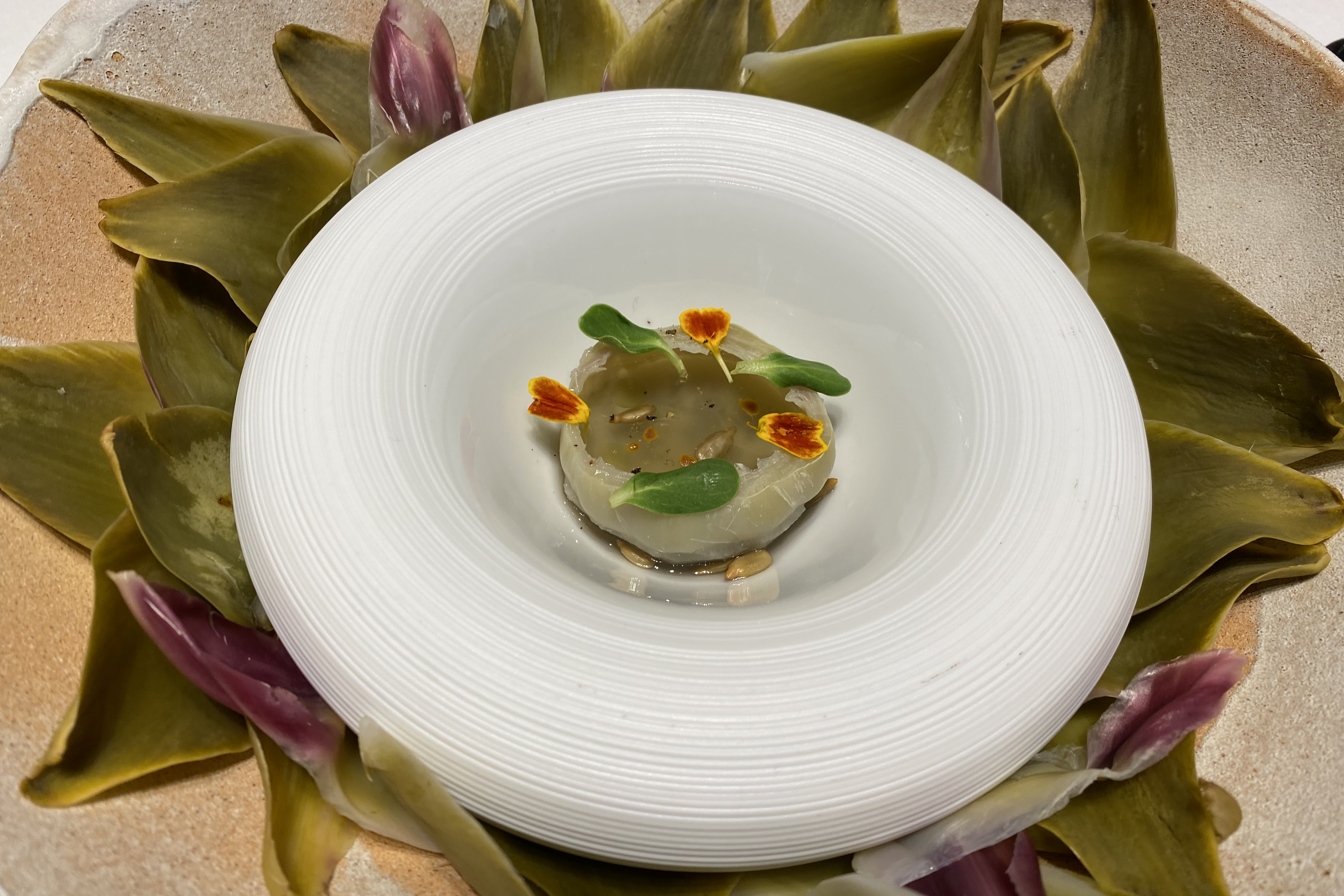 MADRID, 25/03/2023.- A sus 55 años, el brasileño Alex Atala cree que ha cumplido la "misión de vida" que se impuso como cocinero hace dos décadas, lograr que los productos amazónicos estuvieran en tiendas y restaurantes, aunque opina que la gastronomía de su país está todavía "en proceso de maduración". Atala (Sao Paulo, 1968) ha pasado una semana en Valencia, donde ha cocinado en el biestrellado Ricard Camarena Restaurant y se ha enamorado de la paella, la sepia con mahonesa, el arroz con bogavante y las naranjas, hasta el punto de usar los gajos en sustitución del arroz en un nigiri de pez limón y col picante, cuenta a EFE. En la imagen, detalle del plato alcachofa espigada con miel amazónica y polen en la "jam session: Del Amazonas al Mediterráneo". EFE/Pilar Salas