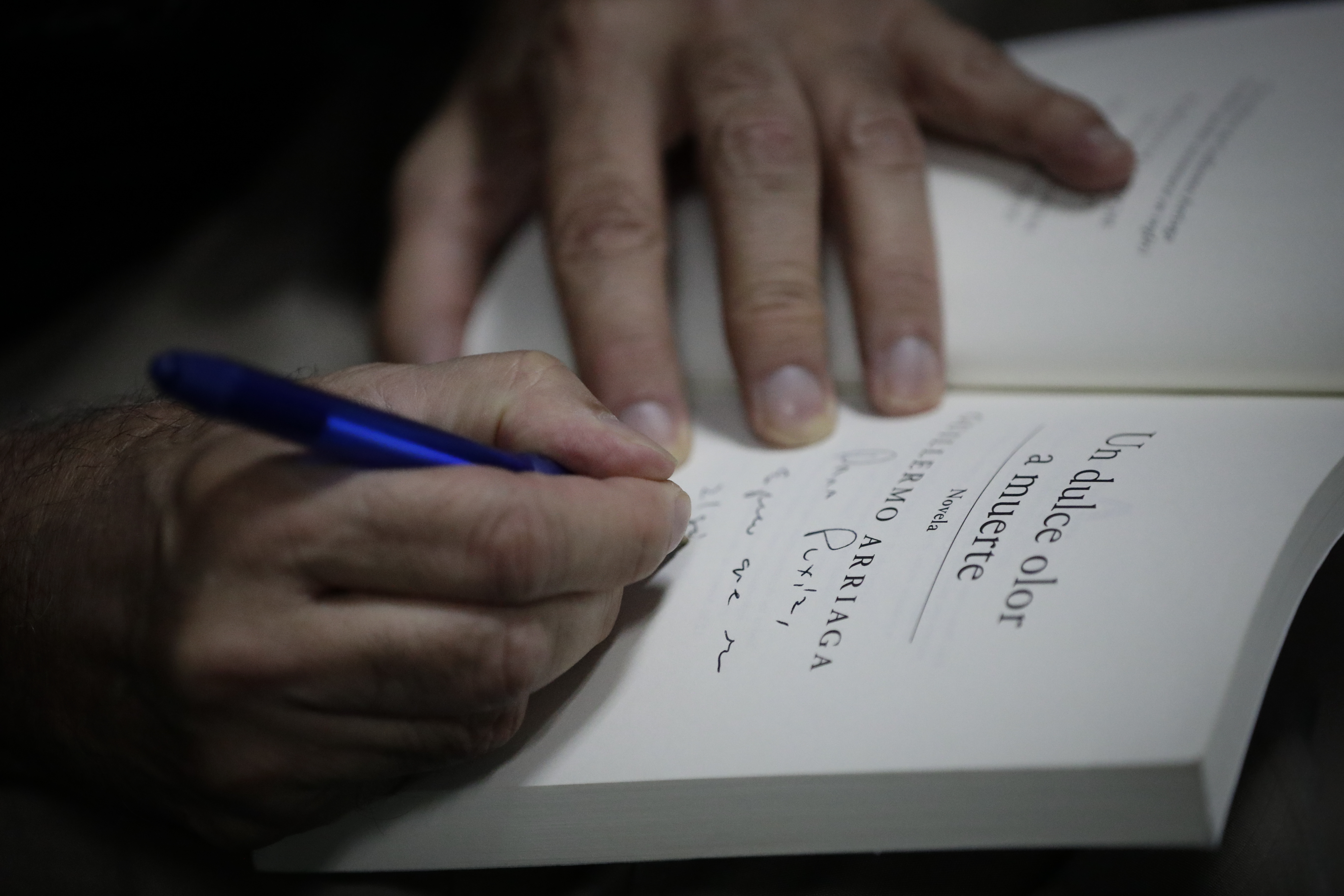 AME2604. CIUDAD DE PANAMÁ (PANAMÁ), 19/08/2023.- El escritor y guionista mexicano Guillermo Arriaga firma un libro, el 18 de agosto de 2023, en la XIX Feria Internacional del Libro de Panamá (FIL 2023), en Ciudad de Panamá (Panamá). Arriaga quiso ser boxeador, y sus libros y películas noquean. Sus obras, tan entre México y Estados Unidos, tratan la violencia del narcotráfico, la migración irregular o cómo puede imponerse la mentira en una sociedad por un supuesto bien común. EFE/ Bienvenido Velasco