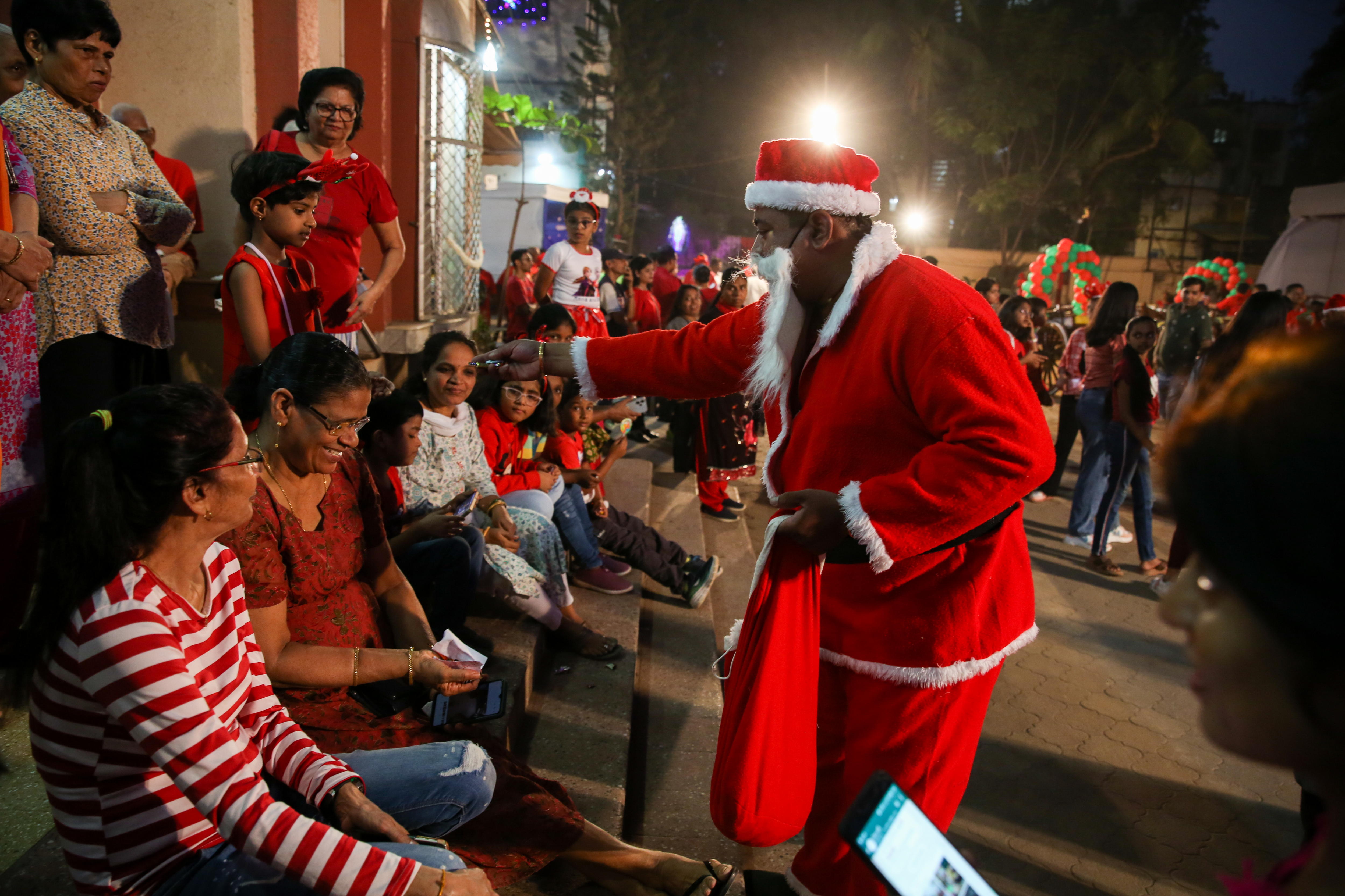 Mumbai (India), 22/12/2023.- A man dressed as Santa Clause distributes sweets during a celebration ahead of the Christmas holidays in Mumbai, India, 22 December 2023. Christian communities around the world will celebrate Christmas on 25 December, which is an annual festival commemorating the birth of Jesus Christ, the central figure of Christianity. EFE/EPA/DIVYAKANT SOLANKI