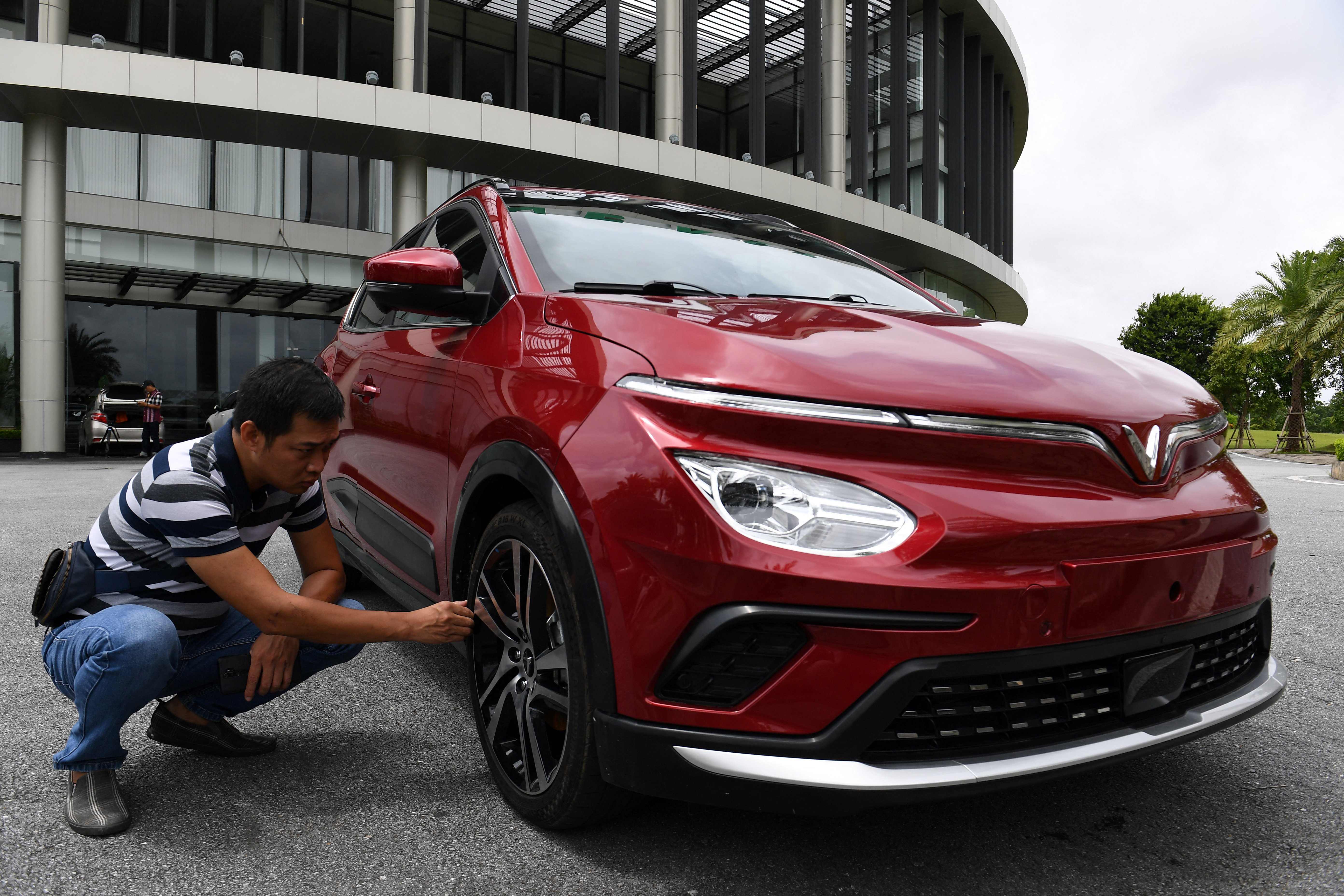 This photo taken on August 26, 2022 shows a worker checking an electric car outside the VinFast electric automobile plant in Haiphong. Having conquered most industries at home, optimistic chiefs at conglomerate Vingroup are setting their sights much higher as they ramp up plans to sell the first ever Vietnamese car in the mighty US market.