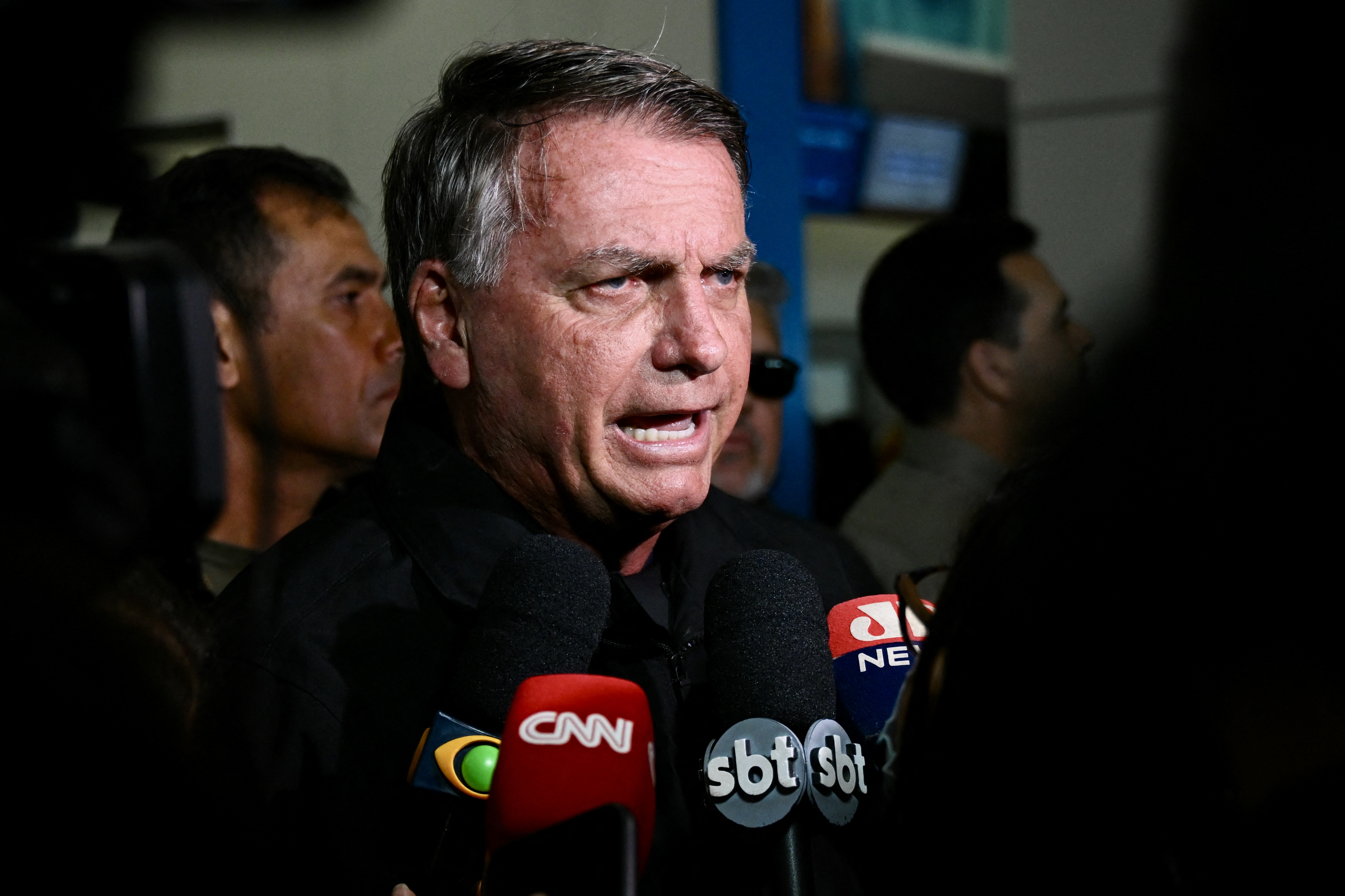 Former Brazilian President Jair Bolsonaro speaks to members of the media after accompanying his wife, Michelle Bolsonaro, to board a plane bound for the US to represent him in President-elect Donald Trump's inauguration after a Brazilian judge denied his request to travel at Brasilia airport on January 18, 2025.