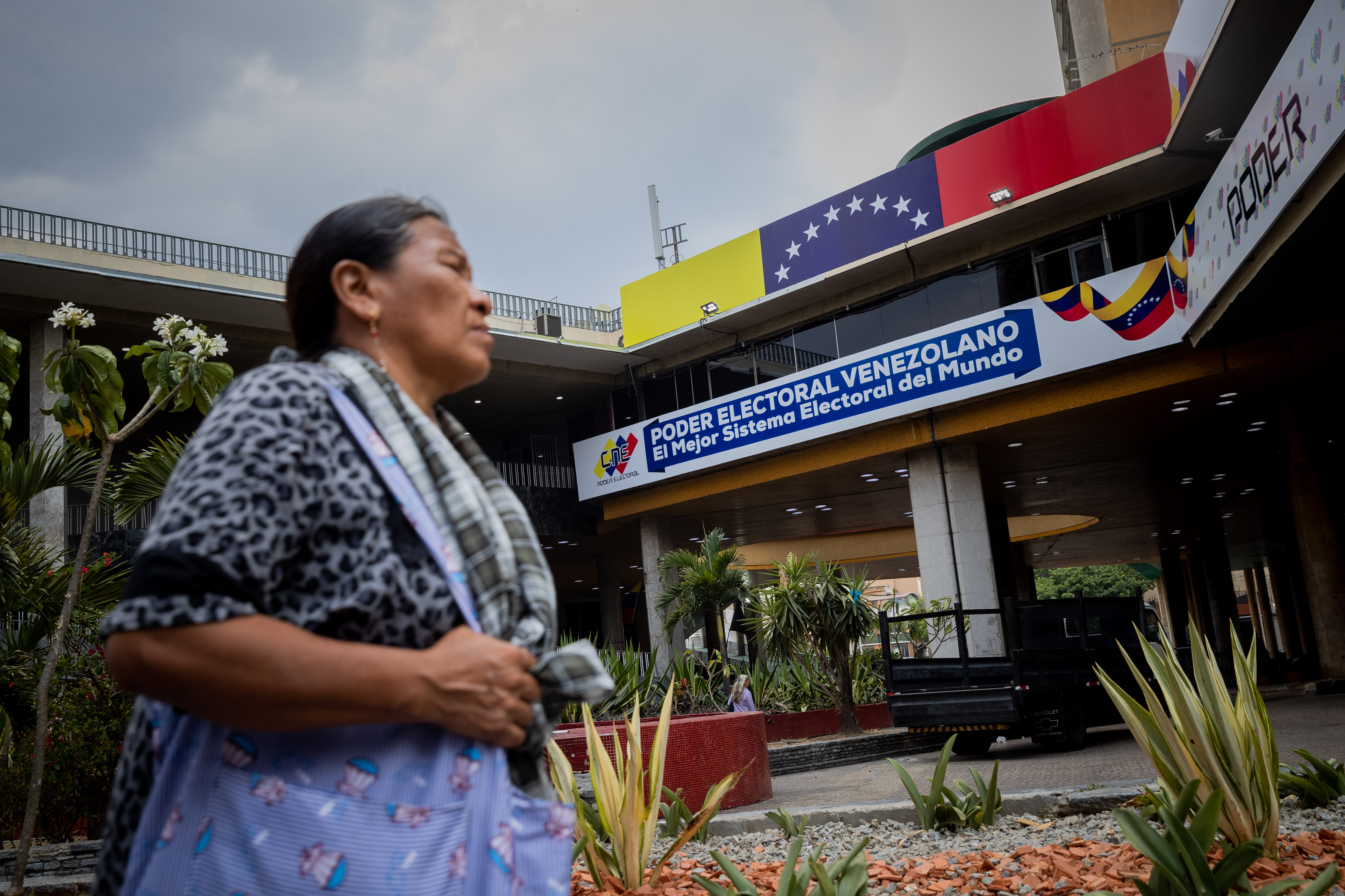 AME8623. CARACAS (VENEZUELA), 19/04/2024.- Una persona camina frente a la sede del Consejo Nacional Electoral (CNE), el 17 de abril de 2024, en Caracas (Venezuela). A 100 días de las elecciones presidenciales en Venezuela, la oposición mayoritaria intenta escoger un candidato de coalición que se enfrente en las urnas a Nicolás Maduro, que buscará su tercer mandato, mientras sigue sin definirse la observación internacional para los comicios, en un país que ya vive una frenética campaña. EFE/ Rayner Peña R.