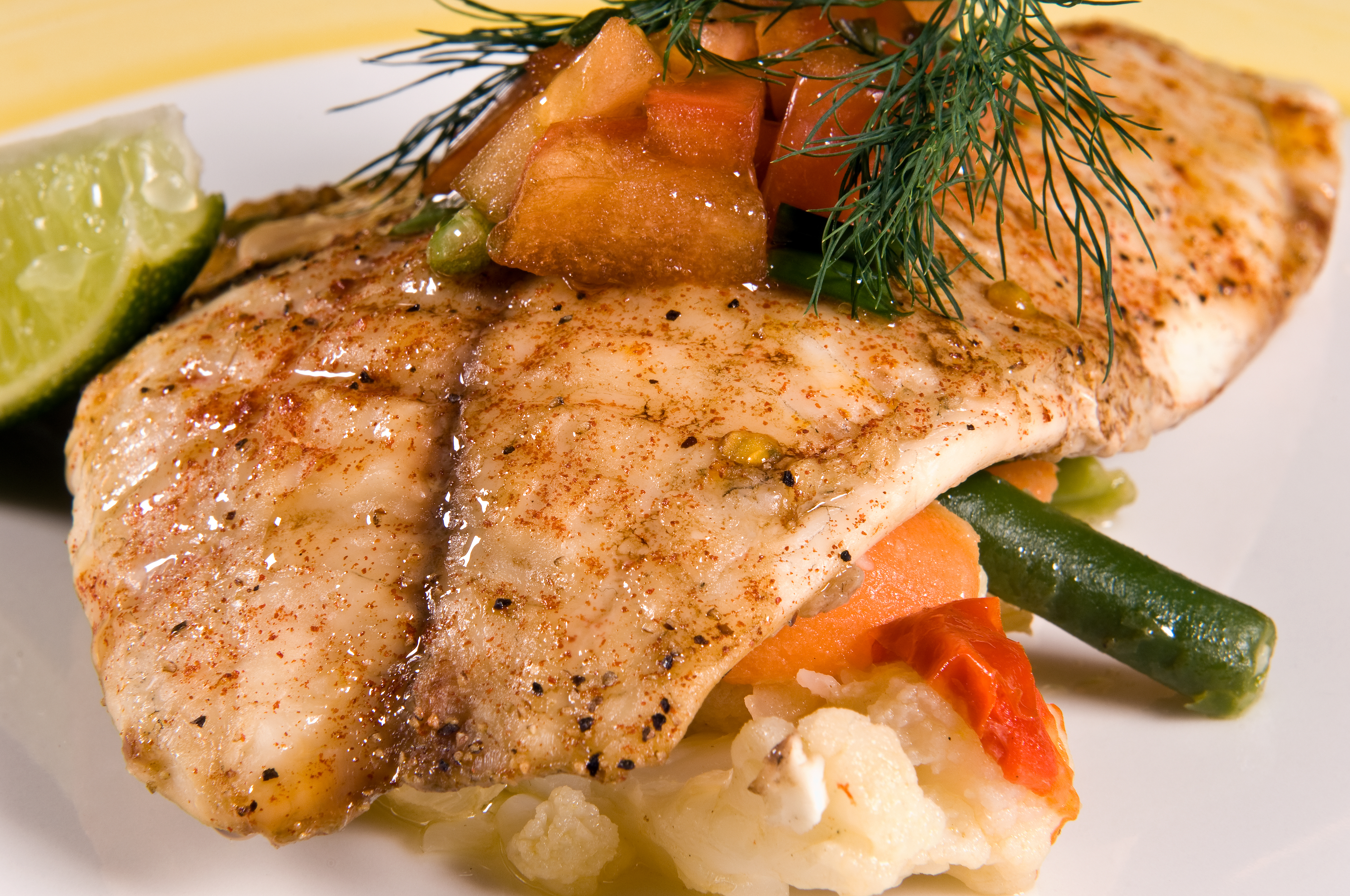 Receta con tilapia acompañada de tomates confitados