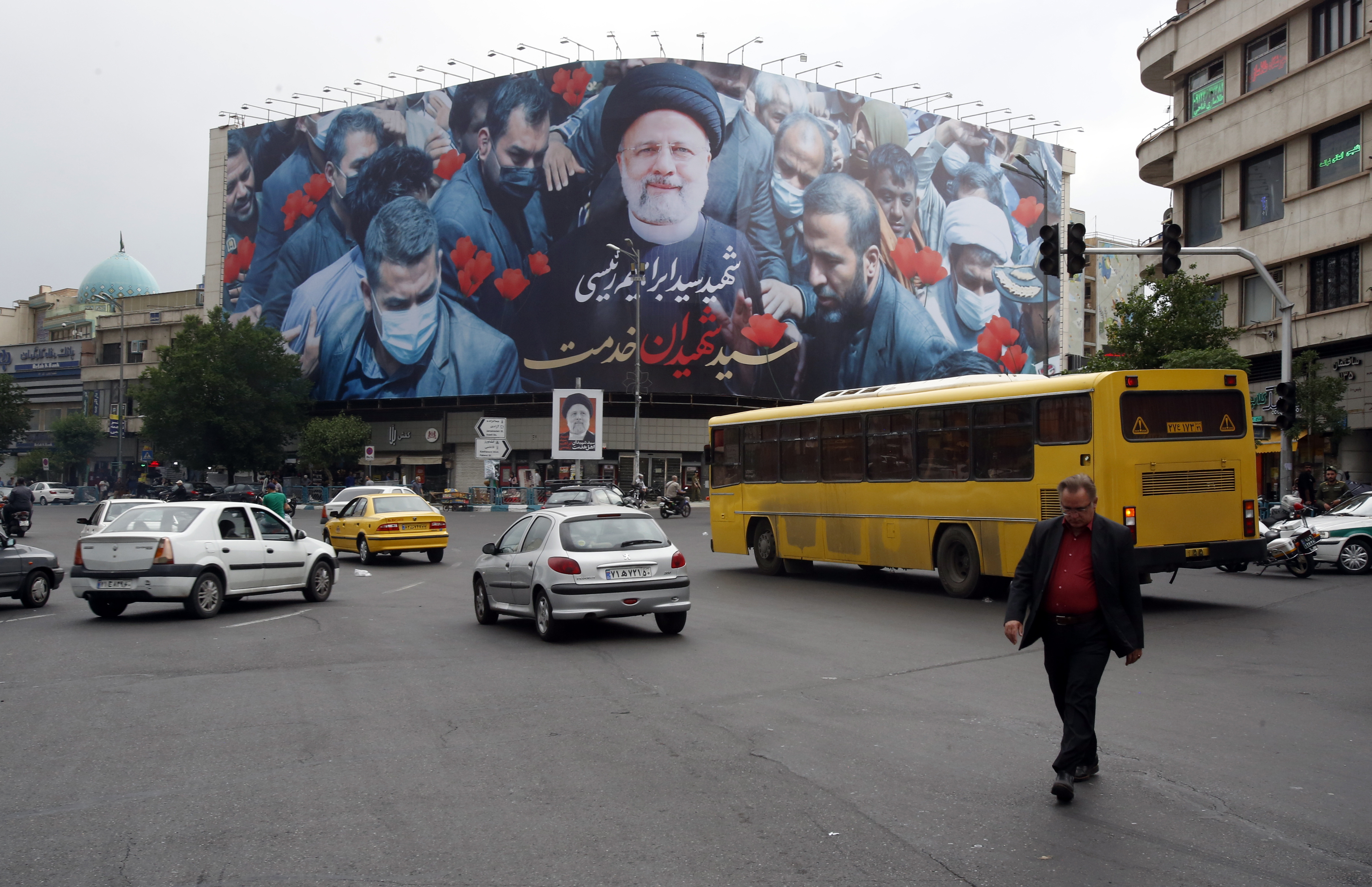Tehran (Iran(islamic Republic Of)), 21/05/2024.- Iranians drive past a poster of late Iranian president Ebrahim Raisi at Enghelab Square in Tehran, Iran, 21 May 2024. Iranian president Raisi and seven others, among them foreign minister Amir-Abdollahian, were killed in a helicopter crash on 19 May 2024, after an official visit in Iran's northwest near the border with Azerbaijan, the Iranian government confirmed. Iran's Supreme Leader Ayatollah Ali Khamenei on 20 May announced a five-day public mourning following Raisi's death. (Azerbaiyán, Teherán) EFE/EPA/ABEDIN TAHERKENAREH