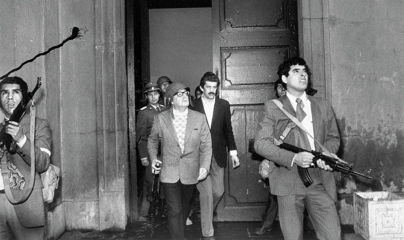 La histórica imagen de Salvador Allende mientras recorría el Palacio de La Moneda con sus hombres, poco antes de morir. /AFP
