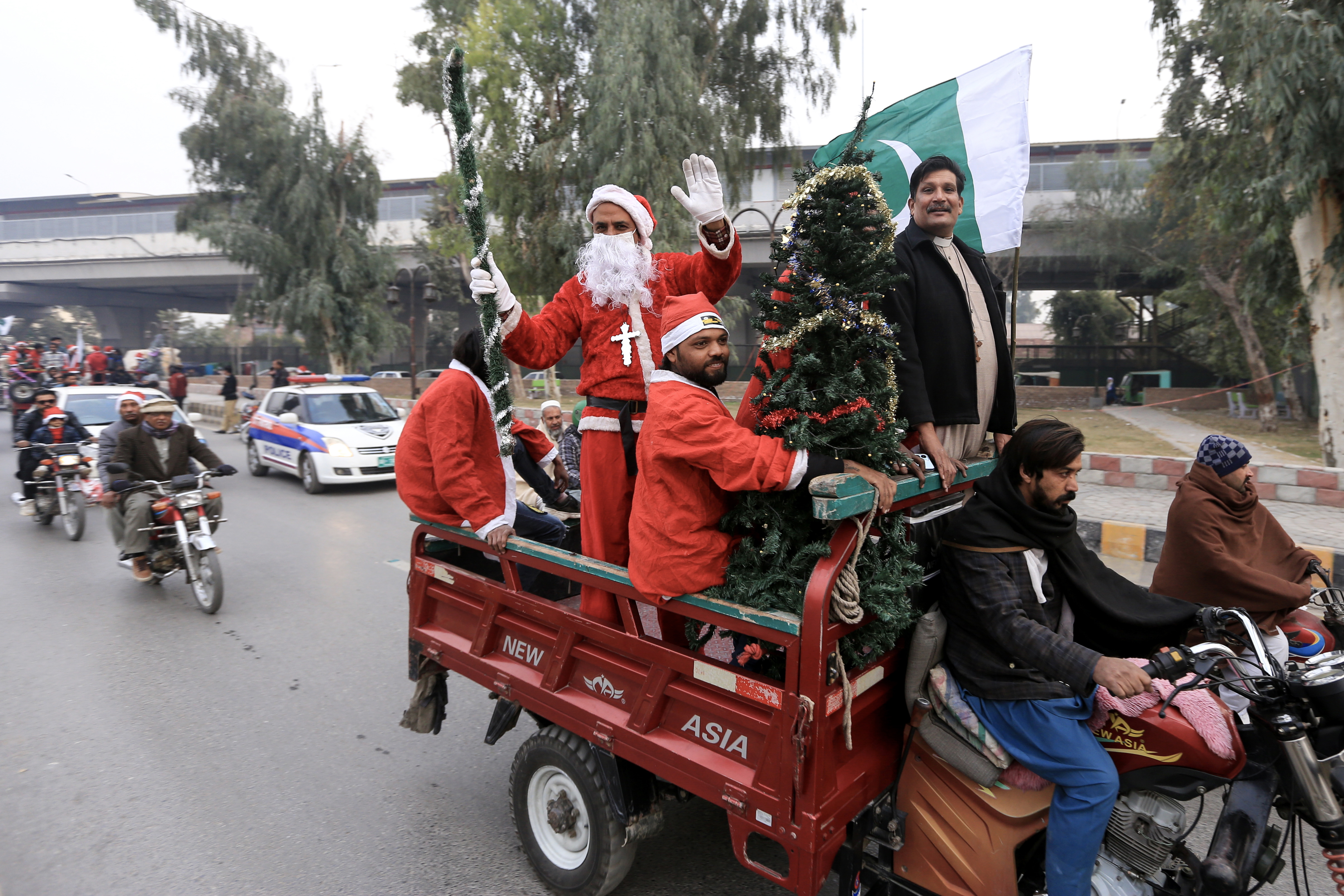 Peshawar (Pakistan), 21/12/2024.- Members of Pakistan's Christian minority dressed as Santa Claus display a Christmas tree while riding on a motorcycle cart during a rally ahead of the Christmas holidays, along a road in Peshawar, Pakistan, 21 December 2024. EFE/EPA/ARSHAD ARBAB