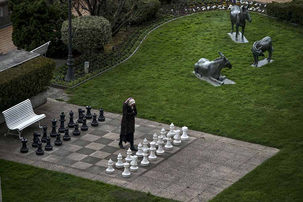Una iraní camina en un tablero de ajedrez en el hotel Beau Rivage Palace, en Suiza. / AFP