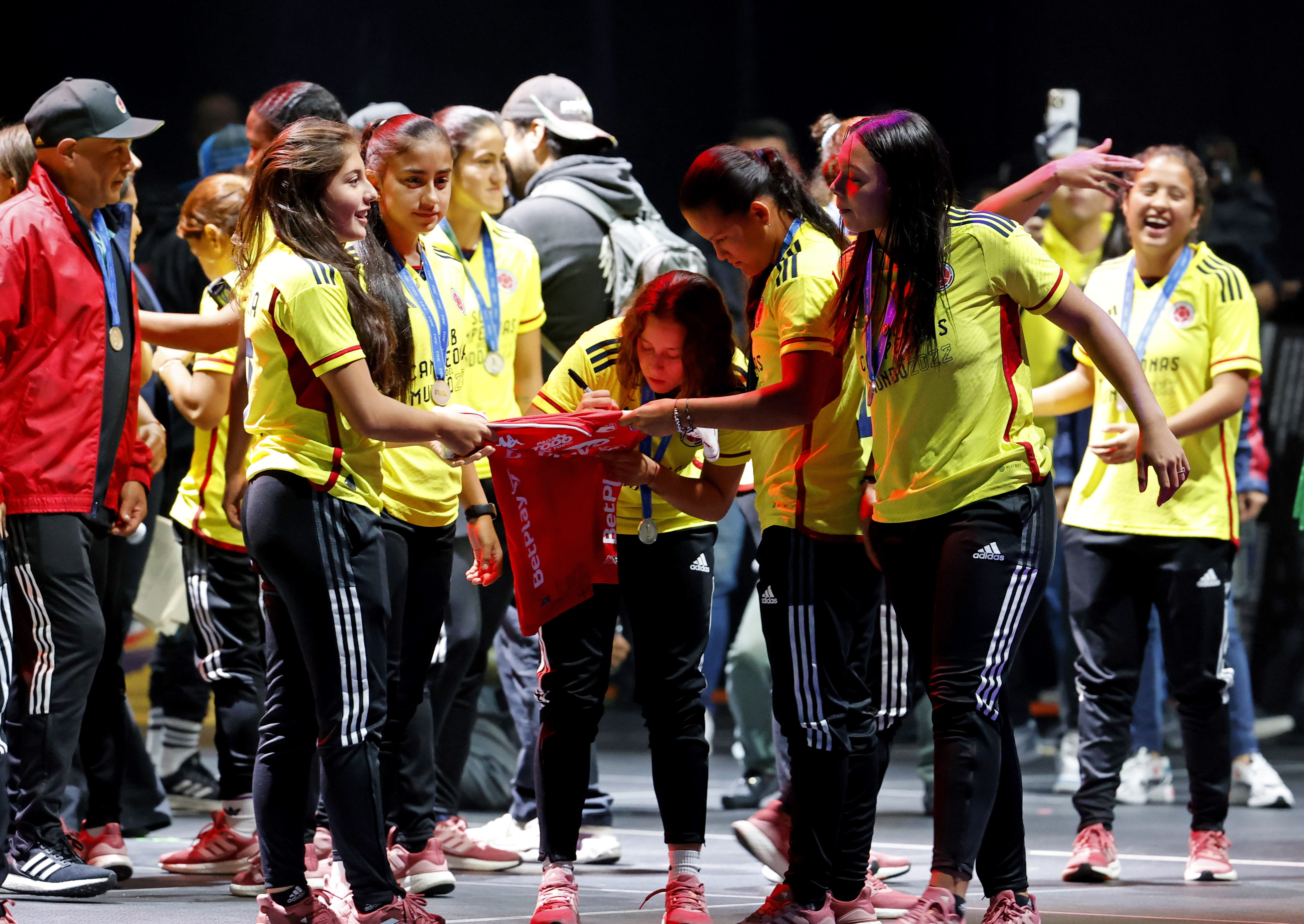 AME776. BOGOTÁ (COLOMBIA), 02/11/2022.- Jugadoras de la selección femenina de fútbol sub-17 de Colombia firman una camiseta hoy, durante un homenaje en Bogotá (Colombia). En medio de salvas de aplausos y con cánticos de "campeonas, campeonas" fueron recibidas este miércoles en Bogotá las jugadoras de la selección colombiana de fútbol femenina sub-17, que logró quedar subcampeona en el Mundial de la India, algo que ningún equipo de Colombia había logrado. EFE/ Mauricio Dueñas Castañeda