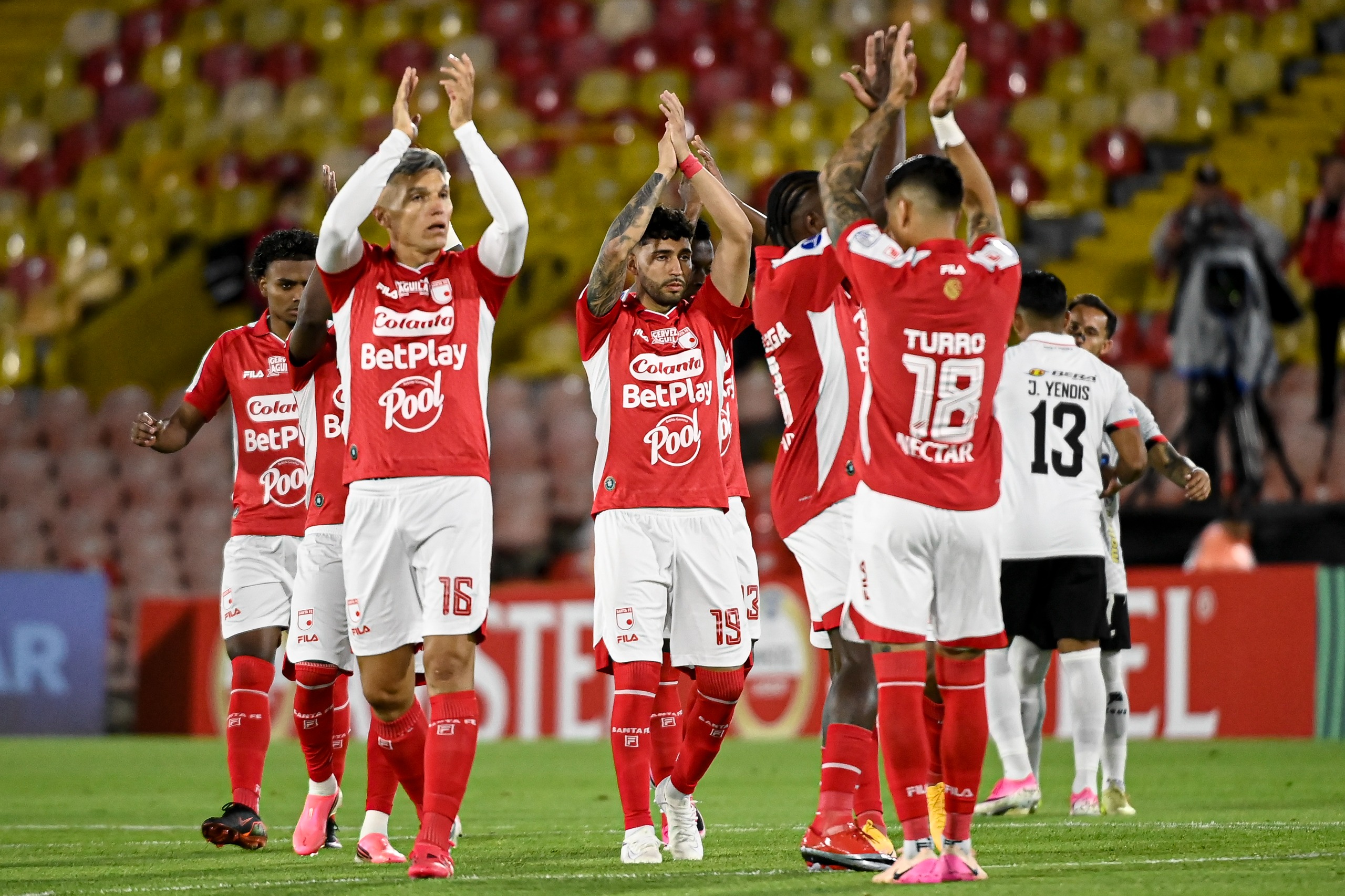 Daniel Torres, Nahuel Bustos y Manuel Olivera agradeciendo el acompañamiento de la hinchada cardenal en el compromiso entre Santa Fe y Caracas en la Copa Sudamericana.