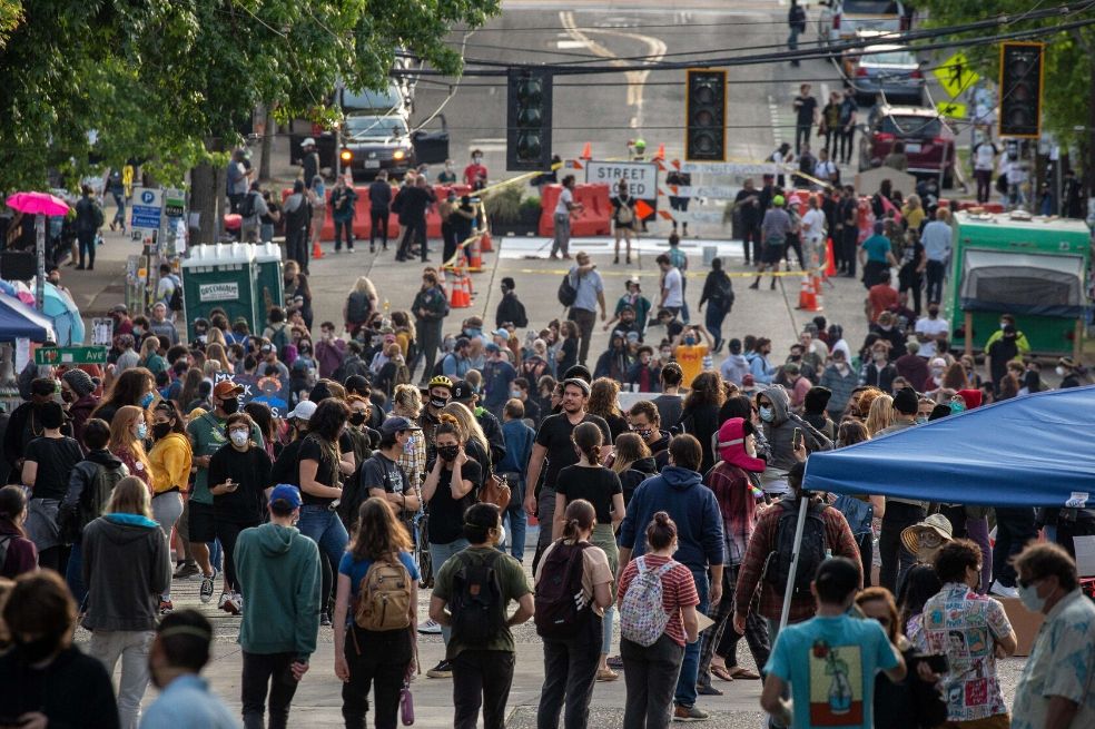 La gente camina cerca del Recinto Este de los Departamentos de Policía de Seattle en la llamada "Zona Autónoma de Capitol Hill". / AFP