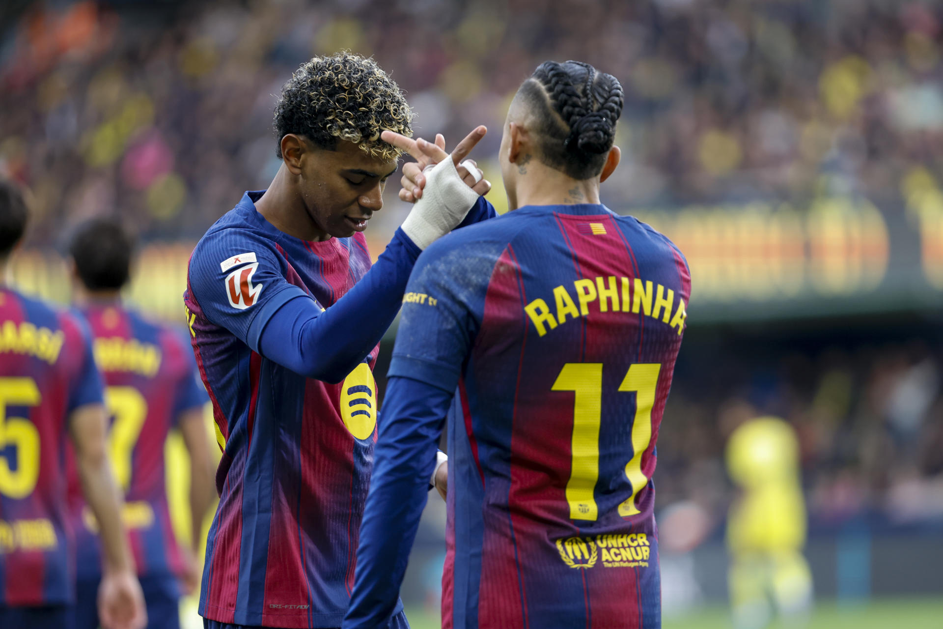 VILLARREAL (CASTELLÓN), 21/12/2025.- El delantero del Barça Raphinha celebra con Lamine Yamal tras anotar el primer gol este domingo, durante el partido de la jornada 17 de LaLiga EA Sports, que disputan Villarreal CF y el FC Barcelona en el Estadio de la Cerámica. EFE/ Ana Escobar
