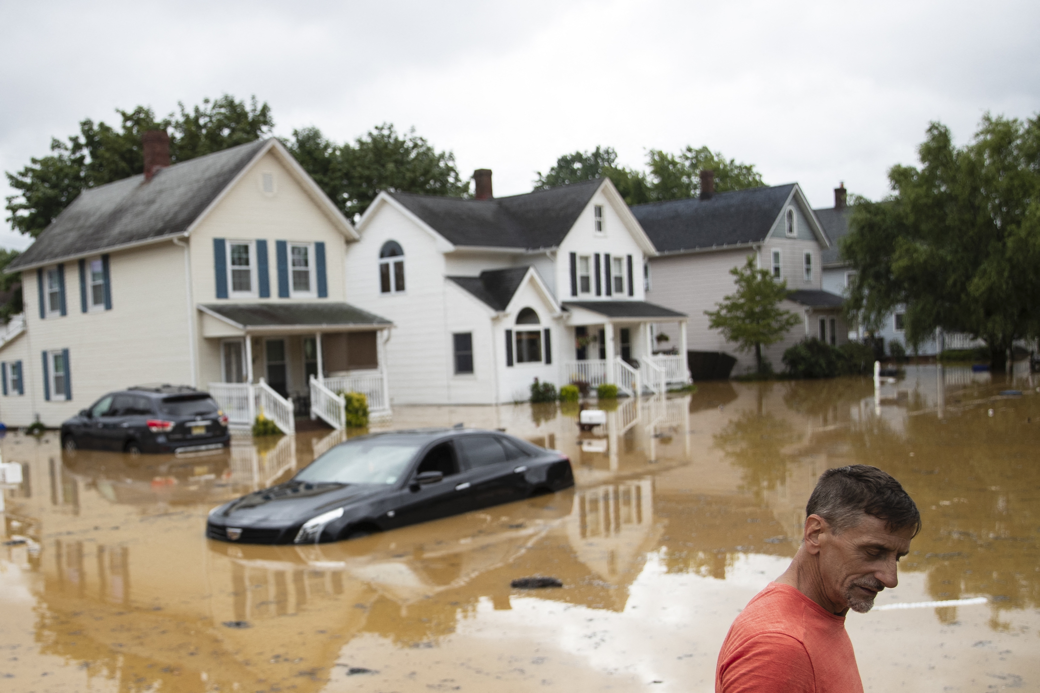Bruce, an evacuated resident, wades through high water following a flash flood, as Tropical Storm Henri makes landfall, in Helmetta, New Jersey, on August 22, 2021. - Tropical Storm Henri slammed into Rhode Island on the US east coast Sunday, knocking out power to thousands of Americans, canceling scores of flights and bringing record rainfall. The storm -- earlier downgraded from a Category 1 Hurricane -- hit land near the town of Westerly at approximately 12:15 PM (1615 GMT), the National Weather Service said.Henri is a rare tropical storm to hit America's northeastern seaboard and comes as the surface layer of oceans warms due to climate change. (Photo by Tom Brenner / AFP)