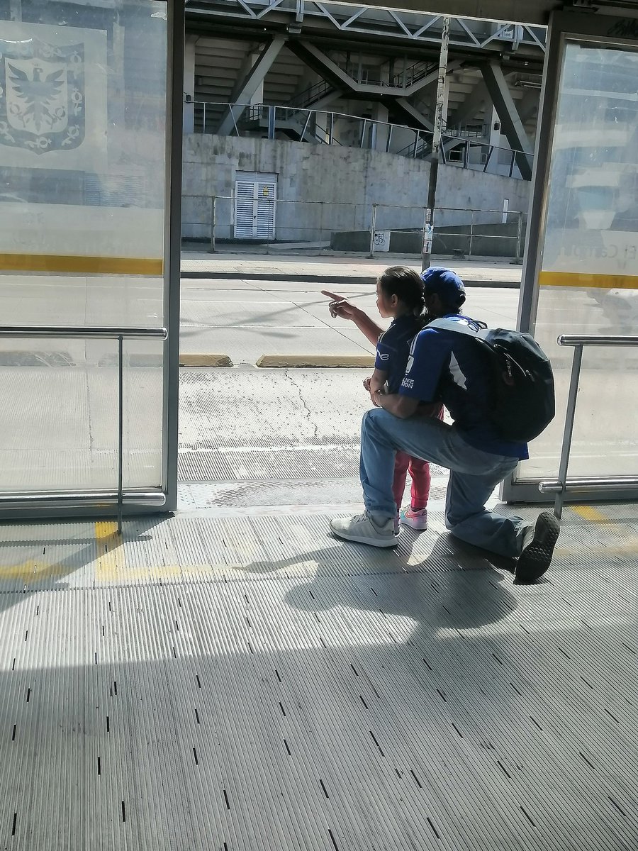 Un hincha de Millonarios le enseña el estadio El Campin desde una estación de Transmilenio.