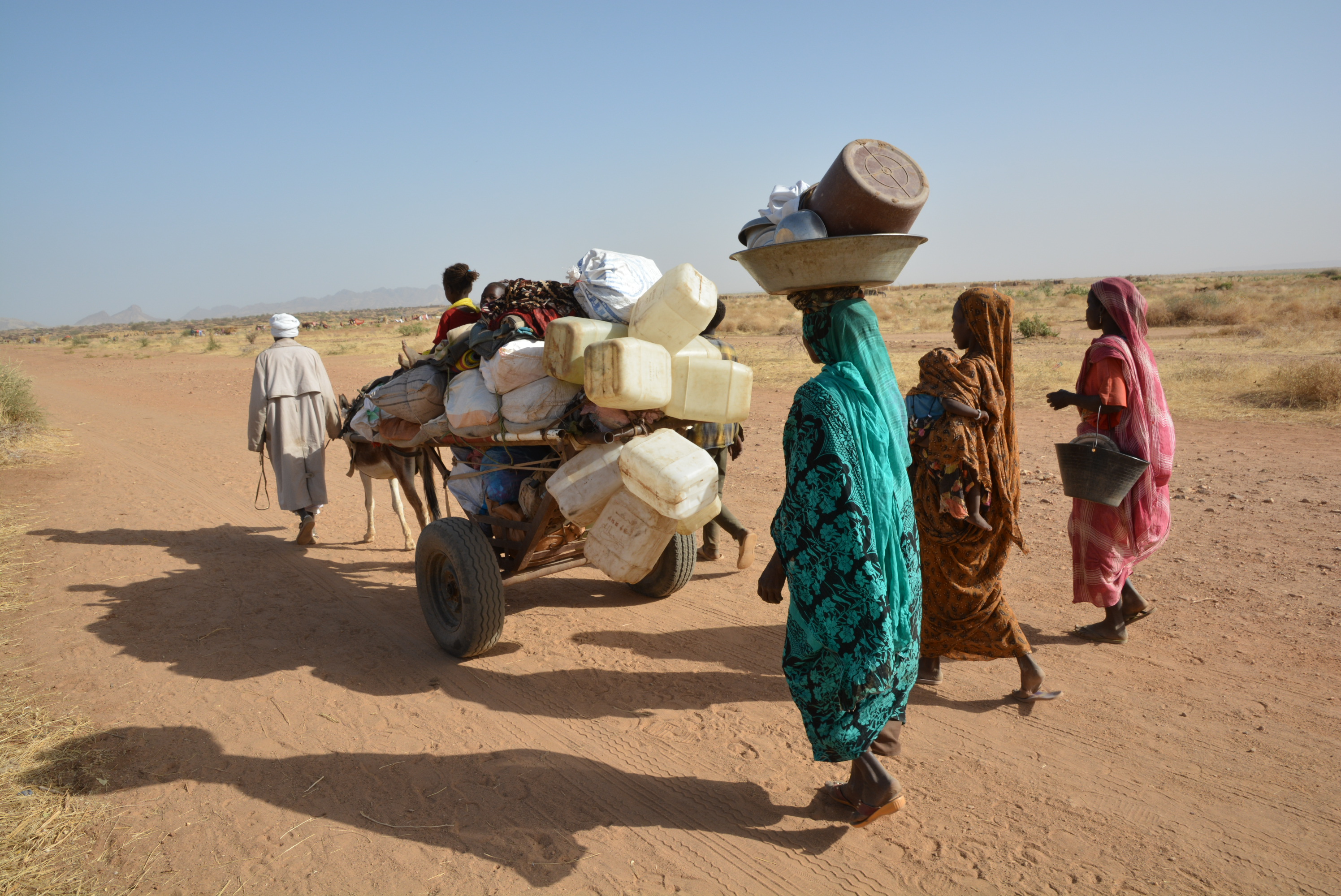 Una familia carga con sus pertenencias, obligada a mudarse debido al conflicto en curso en torno a Tawila. Darfur, Sudán, abril de 2025.