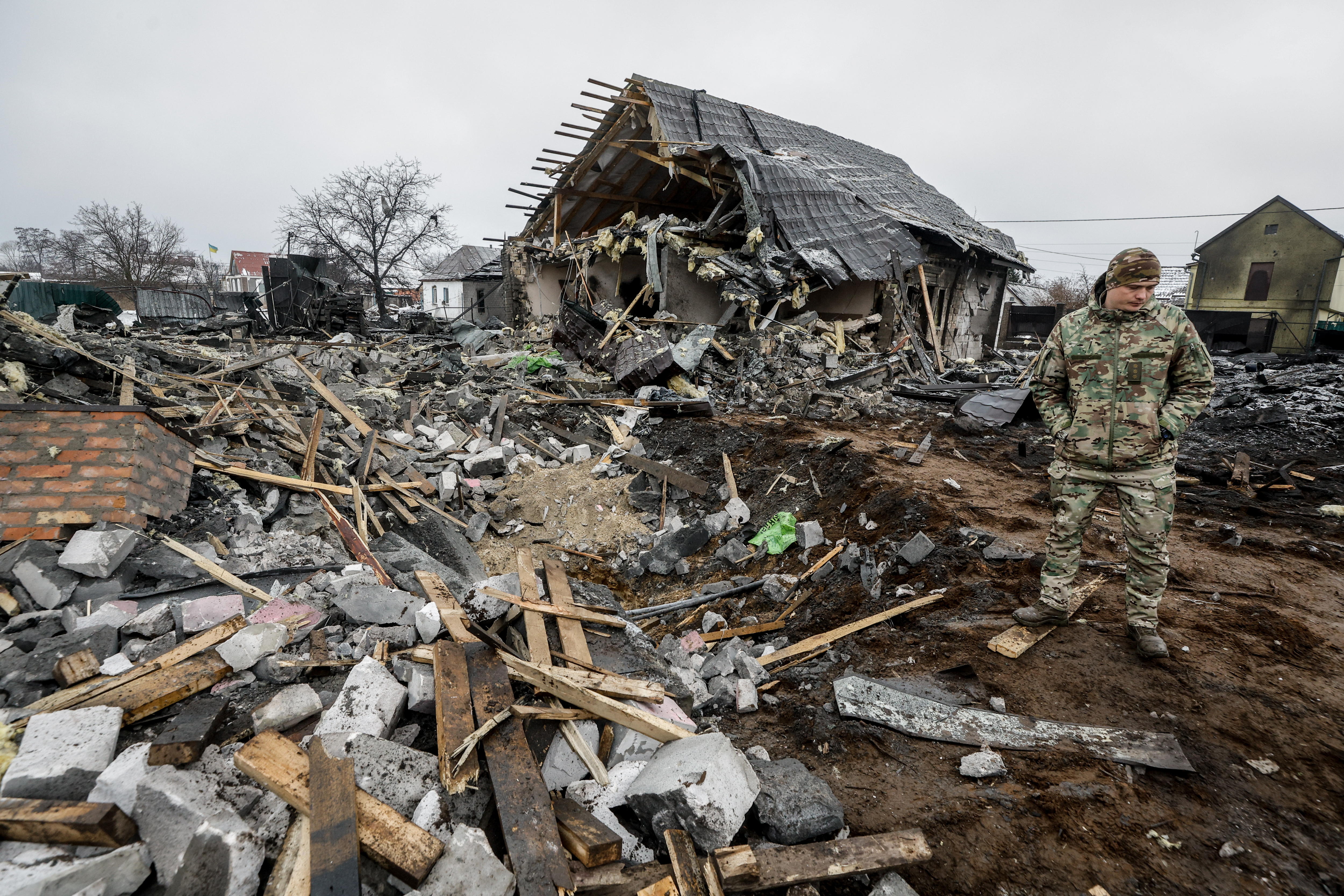 Kyiv (Ukraine), 11/12/2023.- A serviceman looks at a house damaged in a Russian missile strike in Kyiv, Ukraine, 11 December 2023. Russia attacked the Kyiv region with eight ballistic missiles, all of which were reportedly shot down by air defenses.
The falling debris injured one man in his early 30s, and three women were diagnosed with an acute stress reaction due to the attack, said Serhii Popko, the head of the city's military administration. (Rusia, Ucrania, Kiev) EFE/EPA/Sergey Dolzhenko