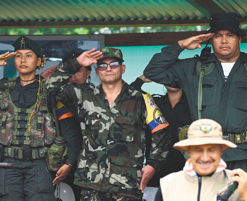 El comandante de la disidencia de las FARC Estado Mayor Central, Iván Mordisco (C), junto al comandante Calarcá Córdoba (D) durante una reunión con comunidades locales en San Vicente del Caguán, departamento de Caquetá, el 16 de abril de 2023.