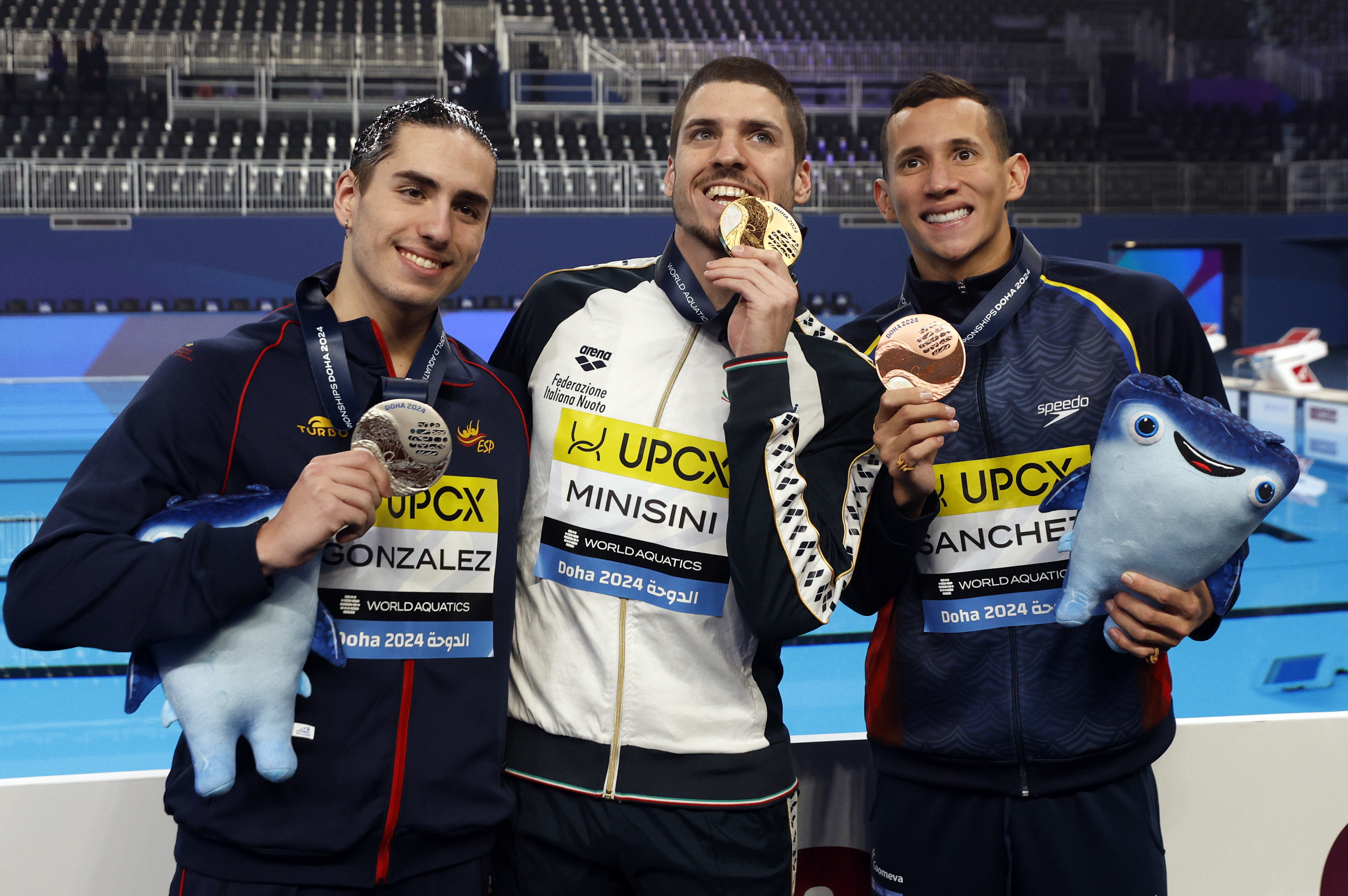 Doha (Qatar), 07/02/2024.- Gold medalist Giorgio Minisini (C) of Italy, silver medalist Dennis Gonzalez Boneu (L) of Spain and bronze medalist Gustavo Sanchez of Colombia celebrate on the podium for the Men Solo Free Final artistic swimming event at the FINA World Aquatics Championships in Doha, Qatar, 07 February 2024. (Italia, España, Catar) EFE/EPA/MOHAMED MESSARA