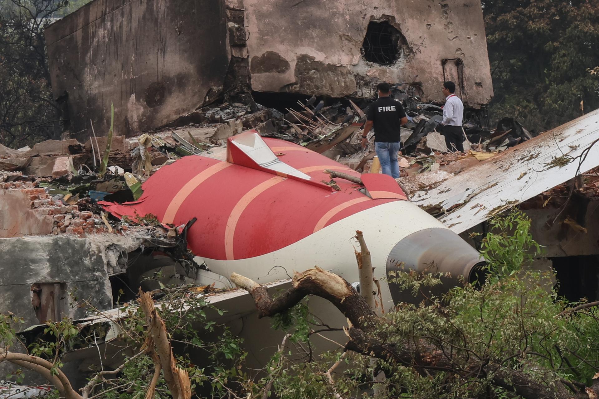 FOTODELDIA AHMEDABAD (India), 13/06/2025.- Los oficiales observan los restos del avión siniestrado en la ciudad de Ahmedabad, Gujarat, India este viernes. La aerolínea Air India confirmó la muerte de 241 personas abordo del avión que se estrelló este jueves en la ciudad de Ahmedabad, en el oeste de la India, y señaló que hay un "solo superviviente" que se encuentra hospitalizado. EFE/ Rajat Gupta
