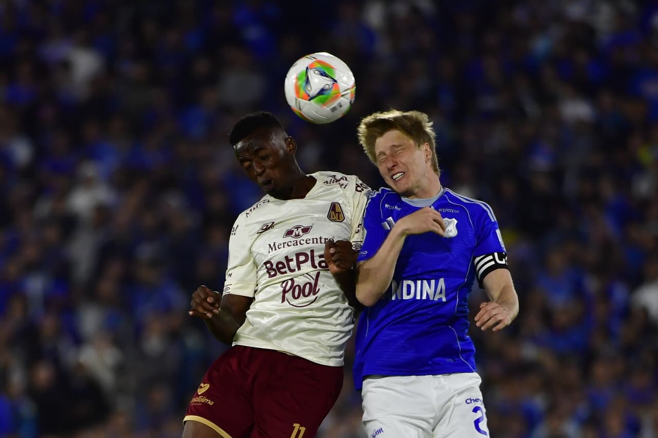 Jader Valencia (Tolima) y Andrés Llinás (Millonarios) disputan un balón aéreo durante un partido en el estadio Nemesio Camacho El Campín de Bogotá este jueves 23 de abril de 2026.
