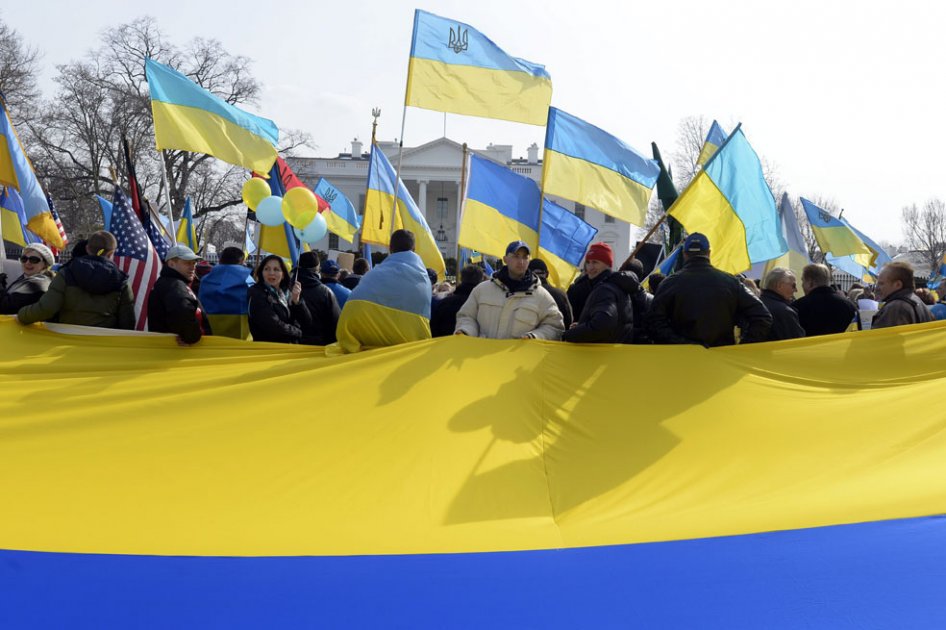 Manifestantes sostienen una bandera de Ucrania para demostrar su apoyo a este país y denunciar las recientes acciones intervencionistas de Rusia, a las afueras de la Casa Blanca en Washington DC.