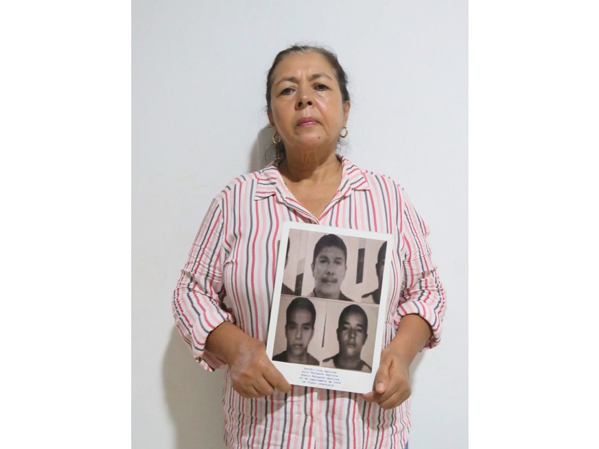 Yaneth Zamudio sostiene el retrato de sus familiares desaparecidos.