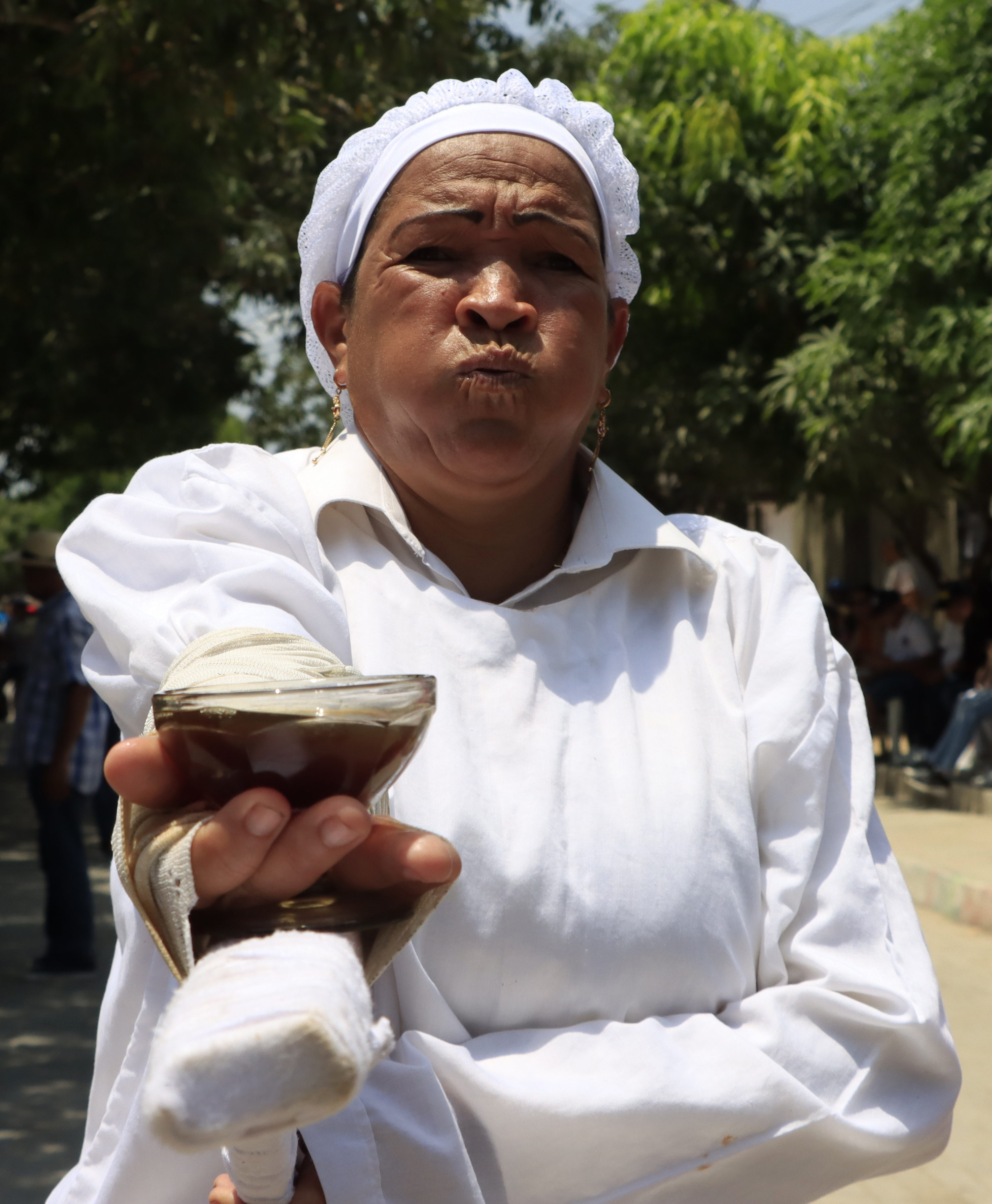 AME1608. SANTO TOMÁS (COLOMBIA), 15/04/2022.- Una penitente sostiene hoy la Copa de la Amargura de Santo Tomas en un ritual que había tenido que aplazarse durante dos años a causa de la pandemia, en Santo Tomás, Atlántico (Colombia). Por las calles de Santo Tomás, un pequeño y muy caluroso poblado colombiano aledaño a la ciudad caribeña de Barranquilla, volvieron a desfilar este viernes los penitentes, célebres por las flagelaciones que algunos de ellos se hacen en la espalda para pagar favores pedidos a Dios. EFE/ Ricardo Maldonado Rozo