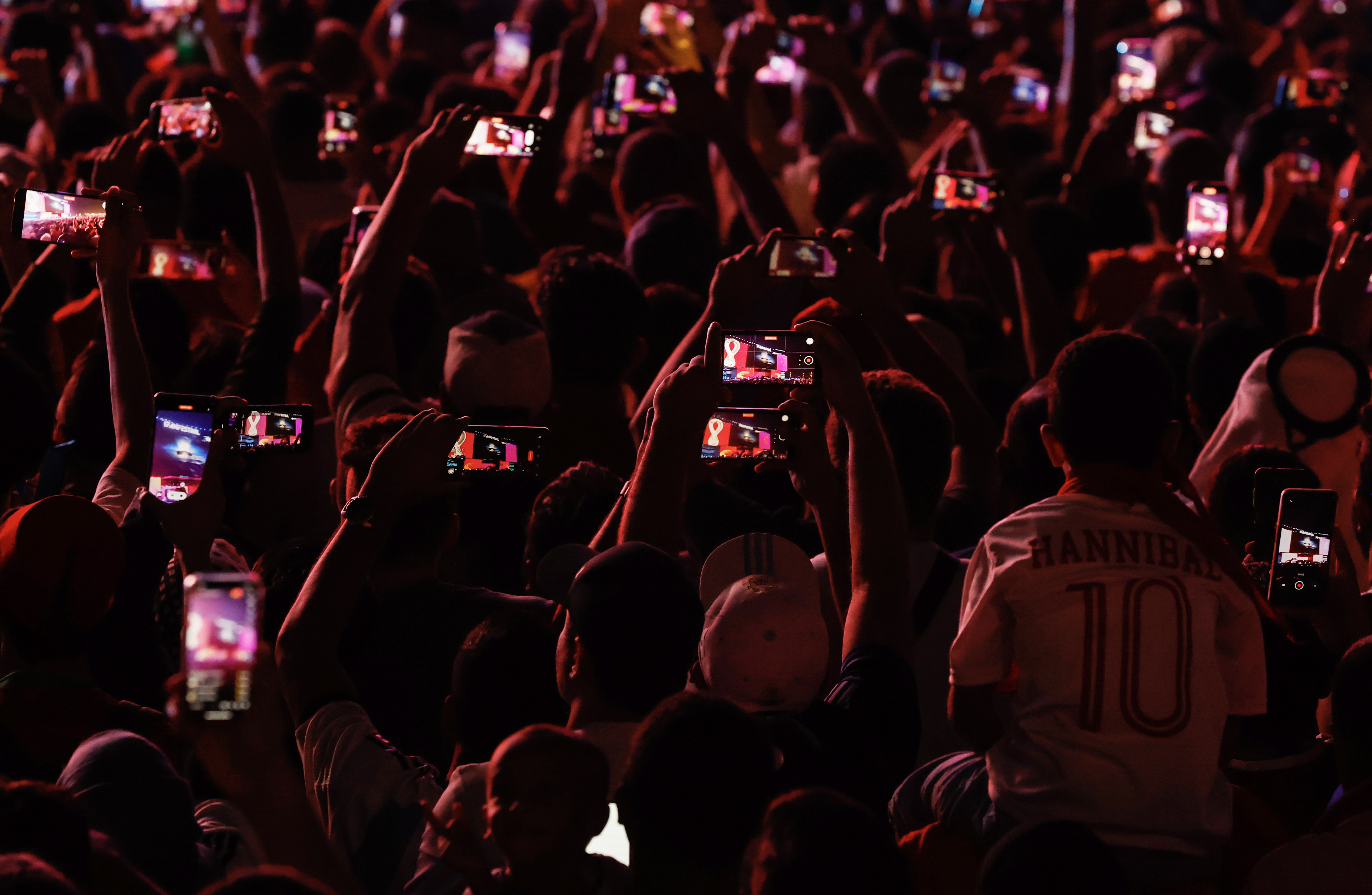Doha (Qatar), 20/11/2022.- Fans raise their mobile phones to record the opening ceremony viewed on the screen at the FIFA World Cup 2022 Fan Festival in Doha, Qatar 20 November 2022. The World Cup 2022 opens with the first match between Qatar and Equador. (Mundial de Fútbol, Catar) EFE/EPA/ROLEX DELA PENA