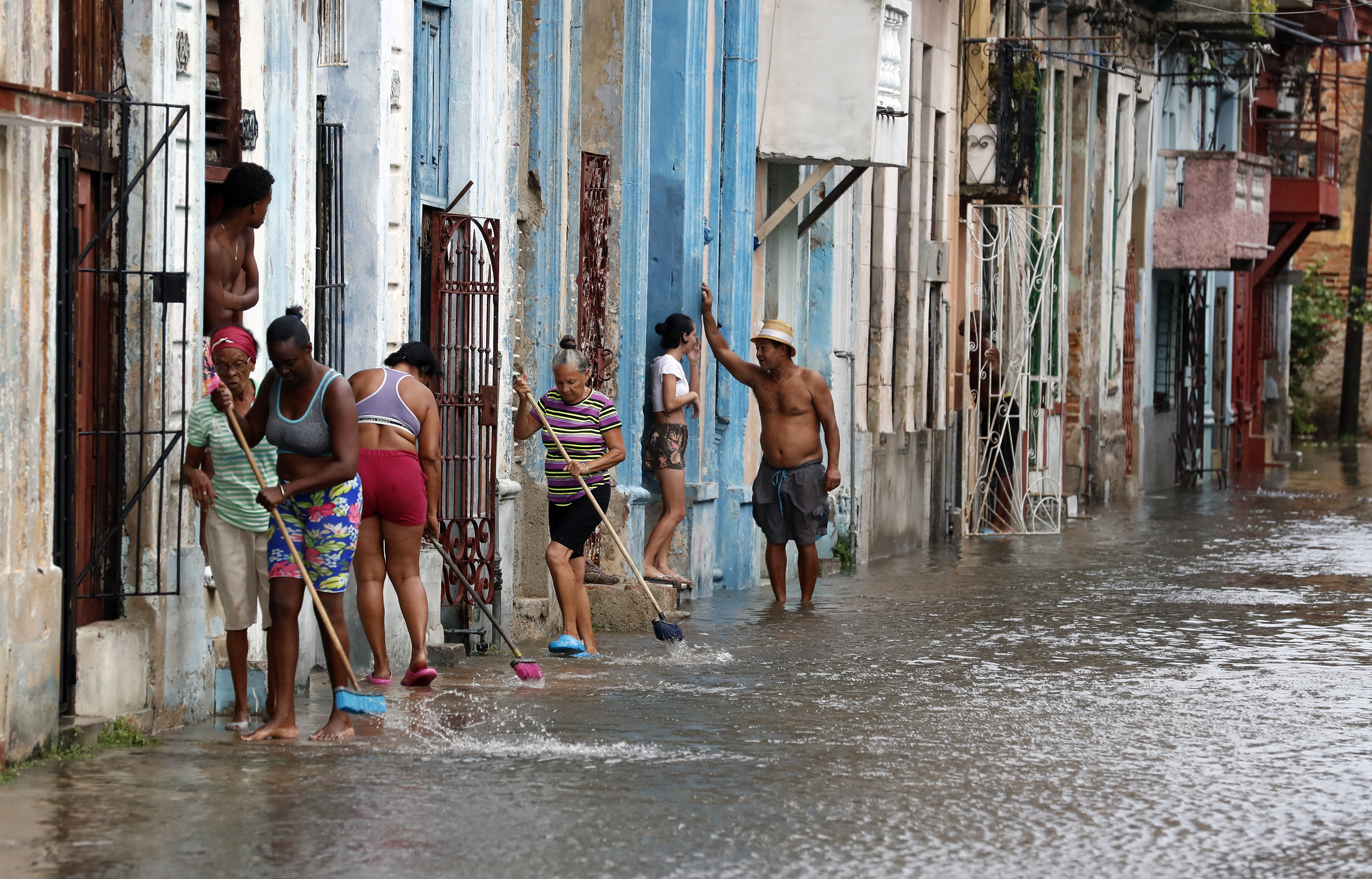 AME5089. LA HABANA (CUBA), 29/08/2023.- Residentes sacan hoy el agua de sus casas en La Habana (Cuba). El Instituto de Meteorología (Insmet) reportó este martes vientos de hasta 133 kilómetros por hora y acumulados de agua superiores a los 100 milímetros (o litros por metro cuadrado) en varias de las zonas afectadas por el huracán Idalia en el oeste de Cuba. Idalia tocó tierra cubana en el cabo de San Antonio, el extremo occidental de la isla este lunes sobre las 21.00 hora local (01.00 GMT, del martes). EFE/Ernesto Mastrascusa