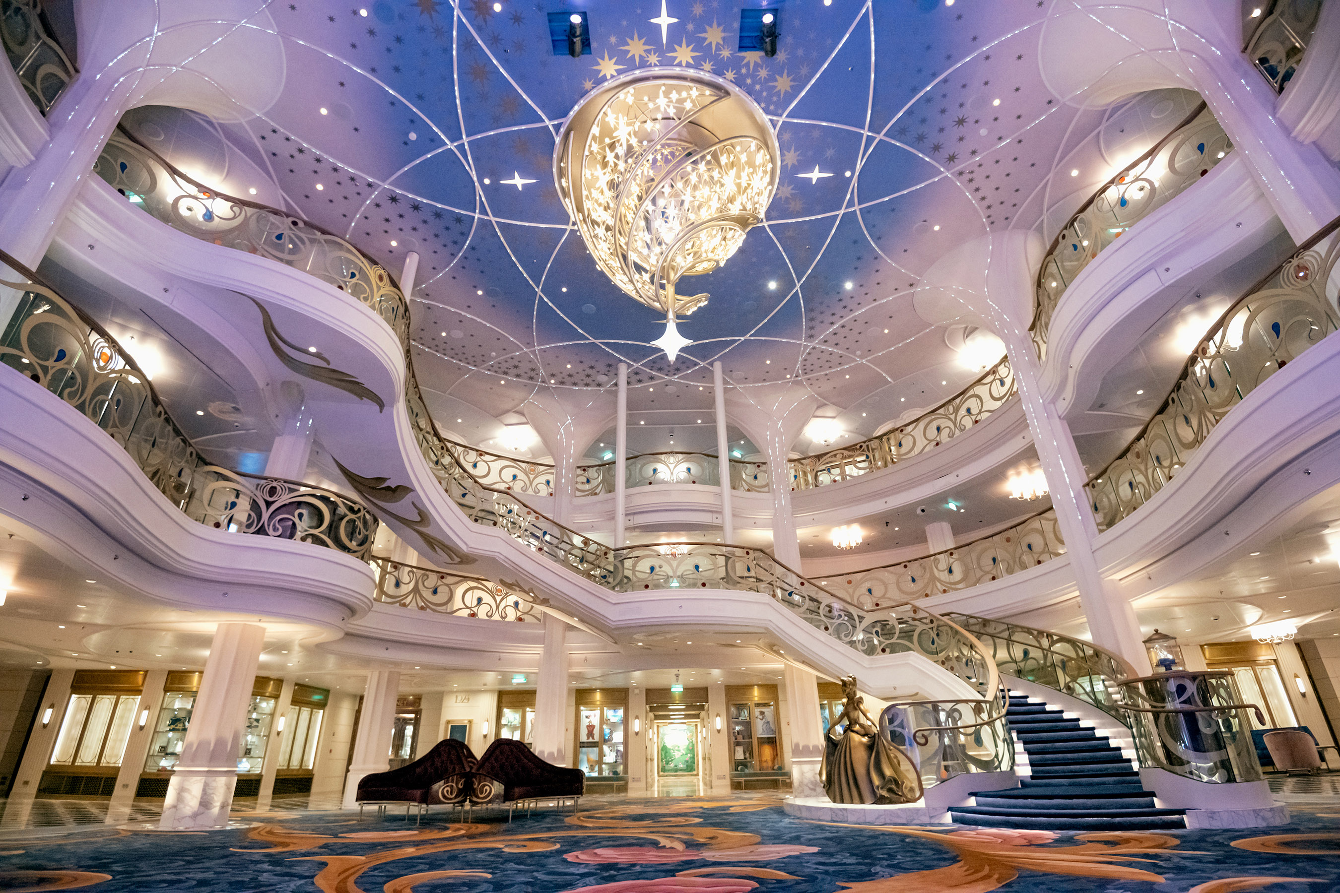 El Grand Hall es un espacio luminoso, ventilado y elegante que da la bienvenida a los visitantes cuando suben a bordo del Disney Wish. Es el castillo en los mares de Disney Cruise Line, un reino de cuento de hadas donde las enredaderas parecen crecer y enroscarse alrededor de columnas que se elevan hasta tres cubiertas y culminan en un candelabro resplandeciente que florece con un estallido de magia.