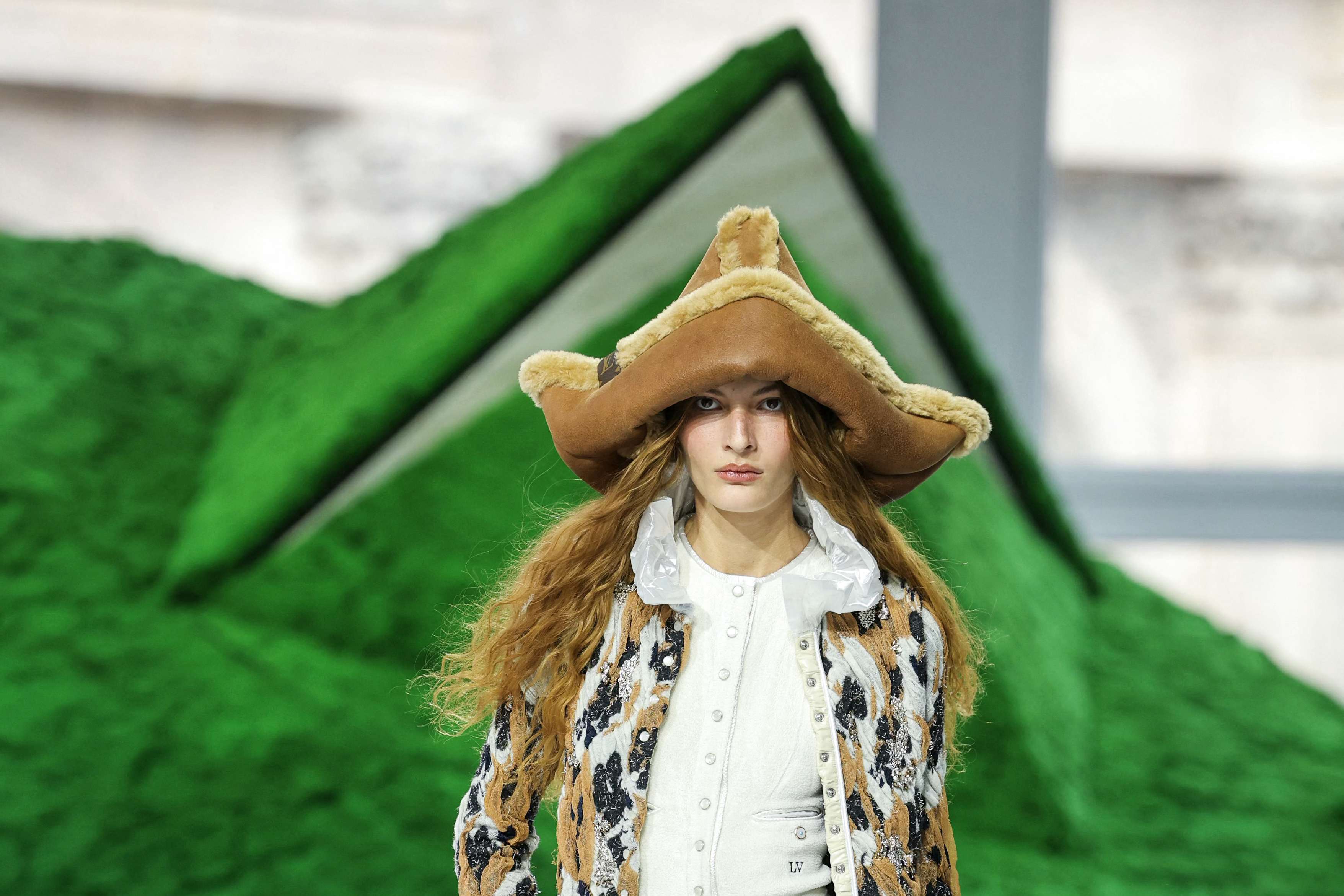 Sombreros de aire pastoril, cabezas cubiertas y siluetas envolventes atravesaron la propuesta de Louis Vuitton, que exploró un imaginario ligado al mundo nómada y sus tradiciones.