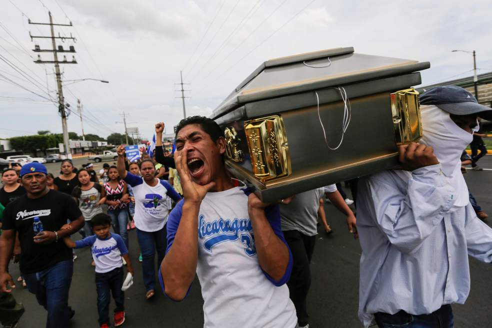 Un grupo de nicaragüenses llora la muerte de un estudiante fallecido durante las protestas en Nicaragua. / AFP