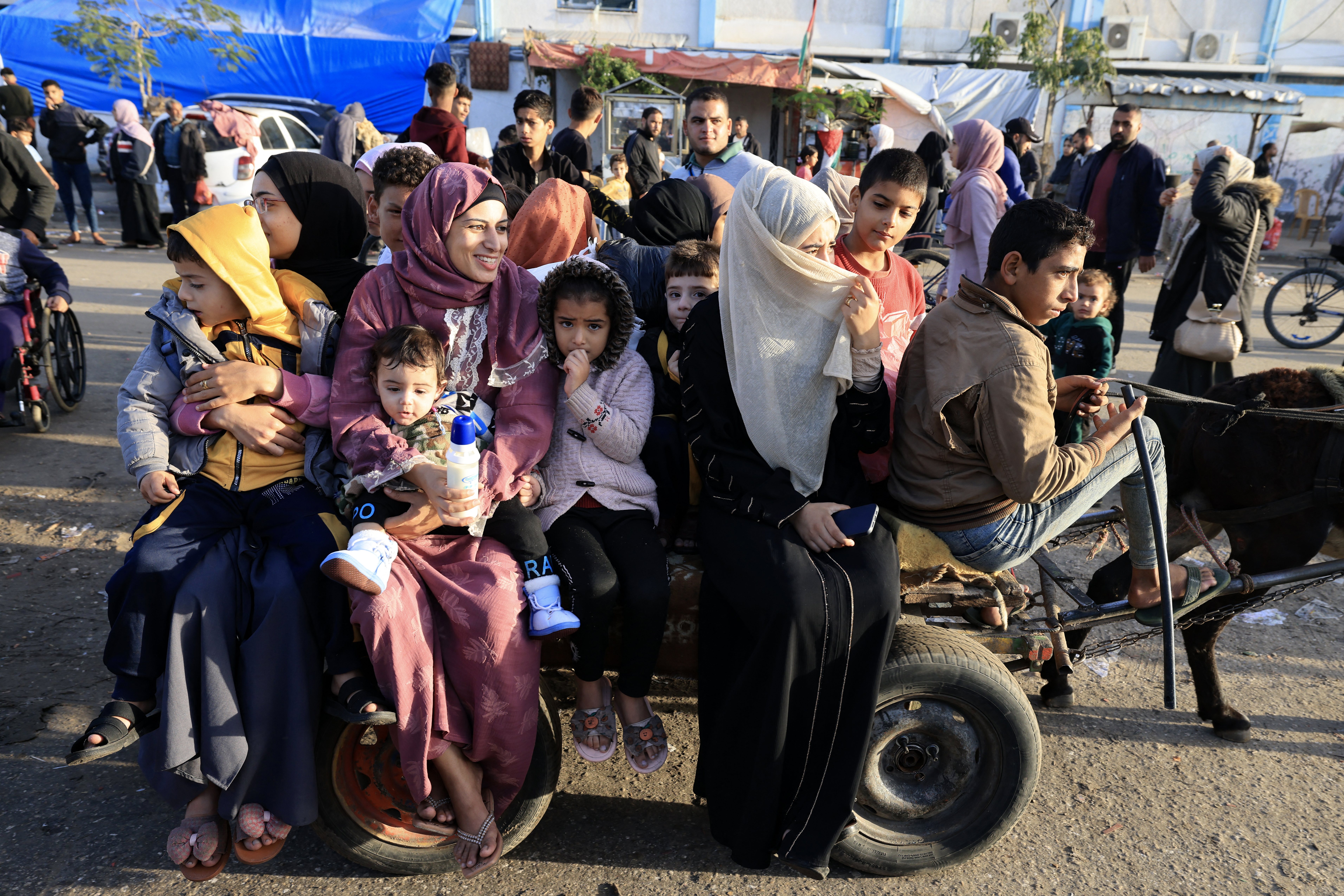 Los palestinos que se habían refugiado en refugios temporales regresan a sus hogares en el este de Khan Yunis, en el sur de la Franja de Gaza, durante las primeras horas de una tregua de cuatro días en las batallas entre Israel y los militantes de Hamás.