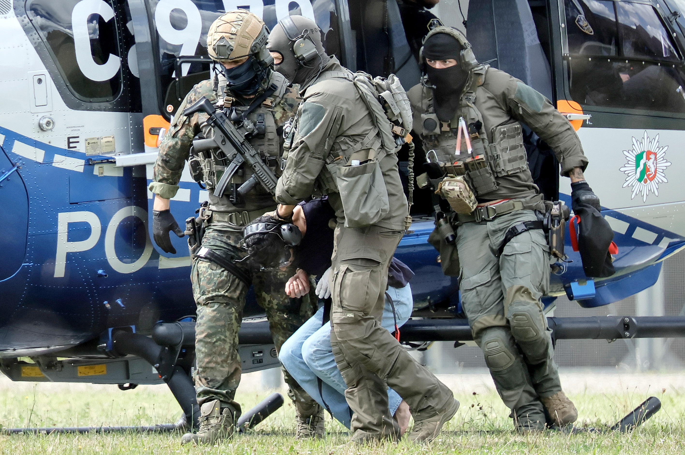 Karlsruhe (Germany), 25/08/2024.- Federal Police officers lead the Solingen knife attack suspect out of the helicopter to his arraignment at the Federal Supreme Court (BGH) in Karlsruhe, Germany, 25 August 2024. The man, who stabbed passers-by at random with a knife during the city festival in Solingen, turned himself in to a police patrol on the evening of 24 August, police said. North Rhine-Westphalia's interior minister Herbert Reul announced late on 24 August that 'the man we've really been looking for the whole day has just been taken into custody.' Three people have been killed and eight others injured, five of them seriously, in the knife attack on 23 August, according to the police. (Alemania) EFE/EPA/RONALD WITTEK